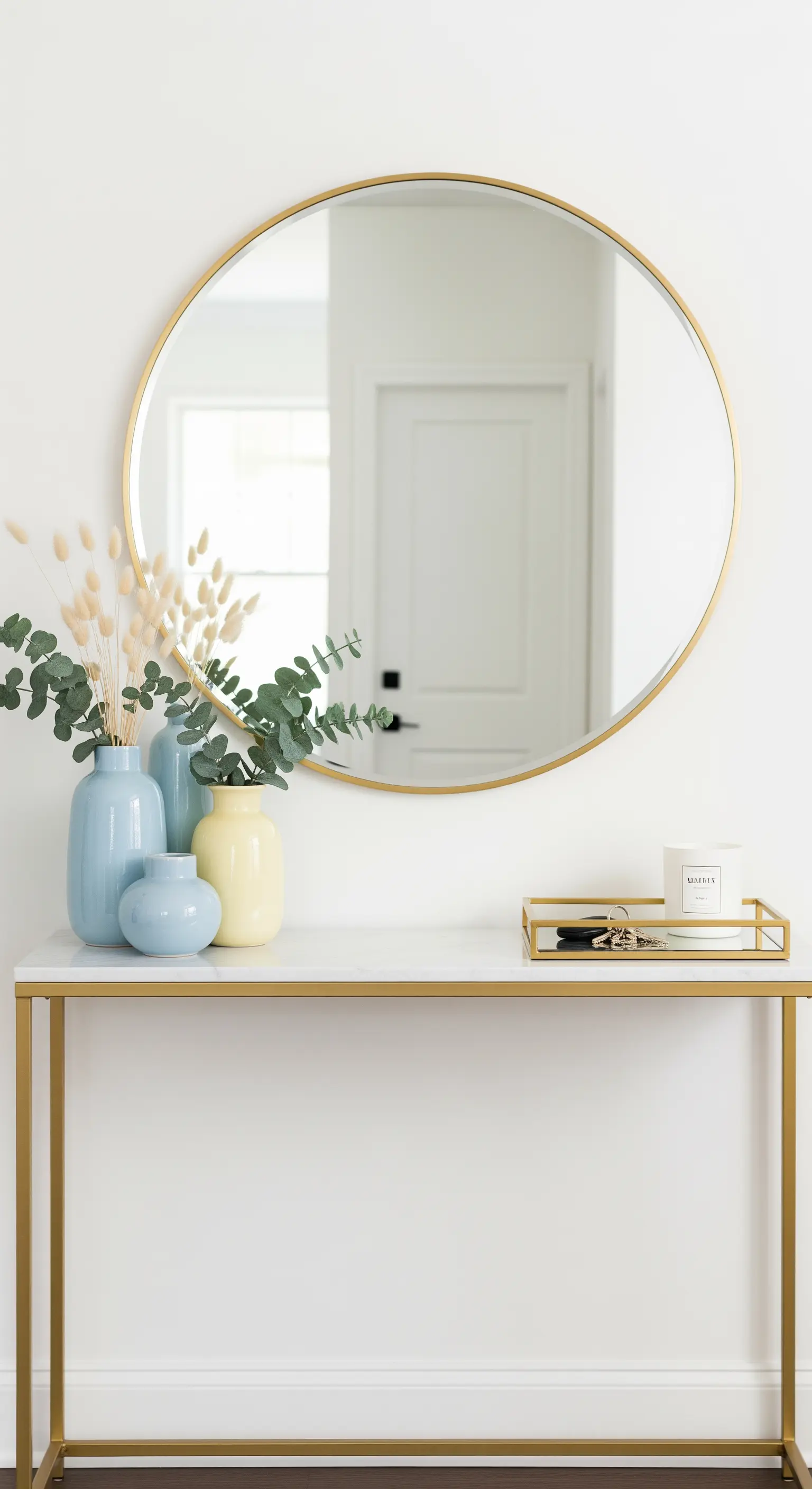 Runder Goldspiegel über Konsole mit blauen Vasen