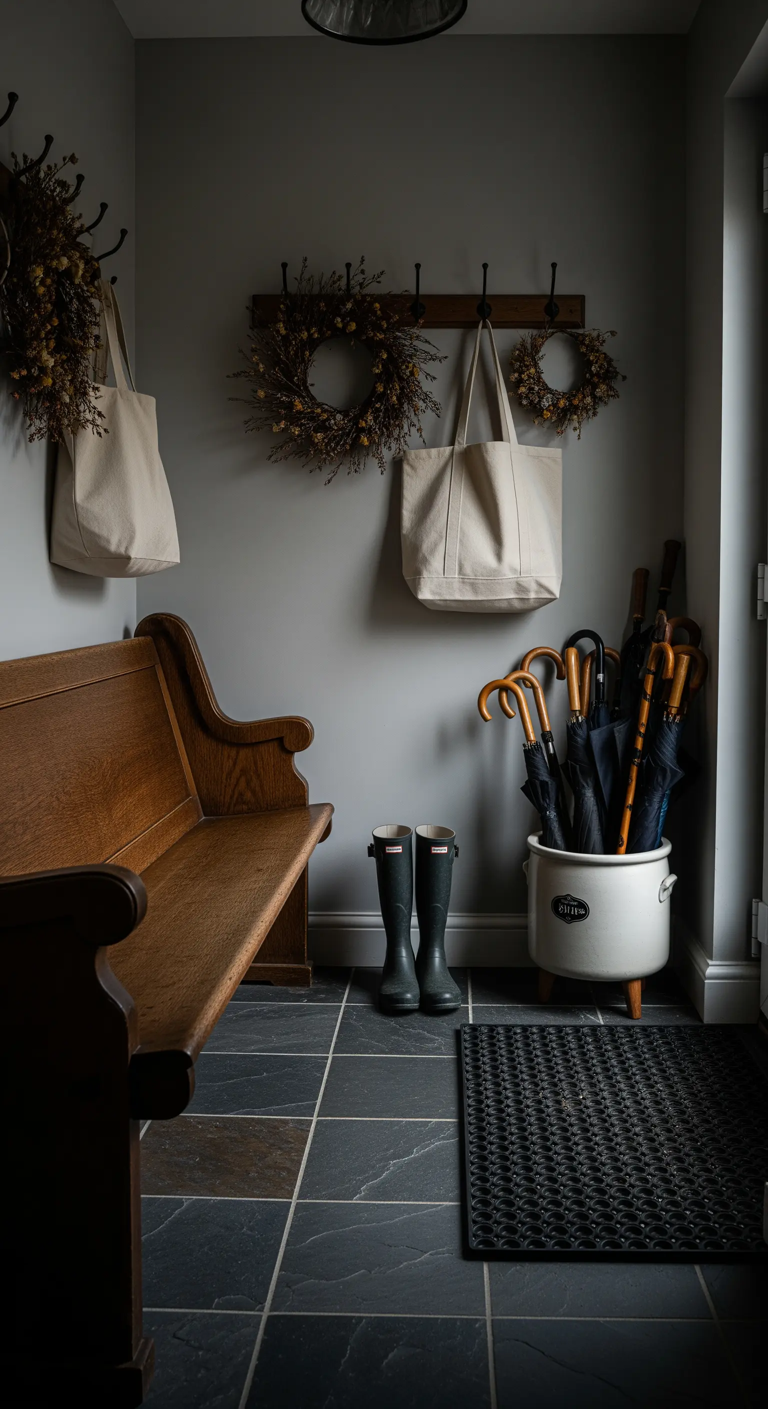 Garderobe mit Gummistiefeln, Taschen und Kränzen
