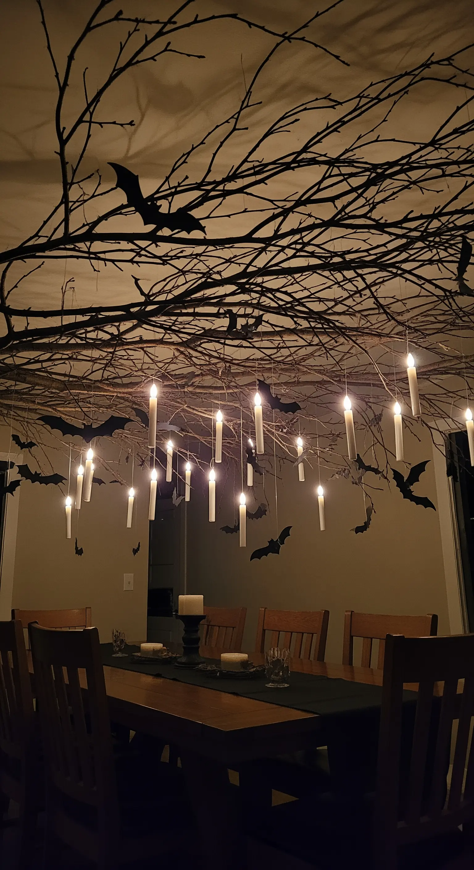 Ast an Decke mit schwebenden Kerzen und Fledermäusen