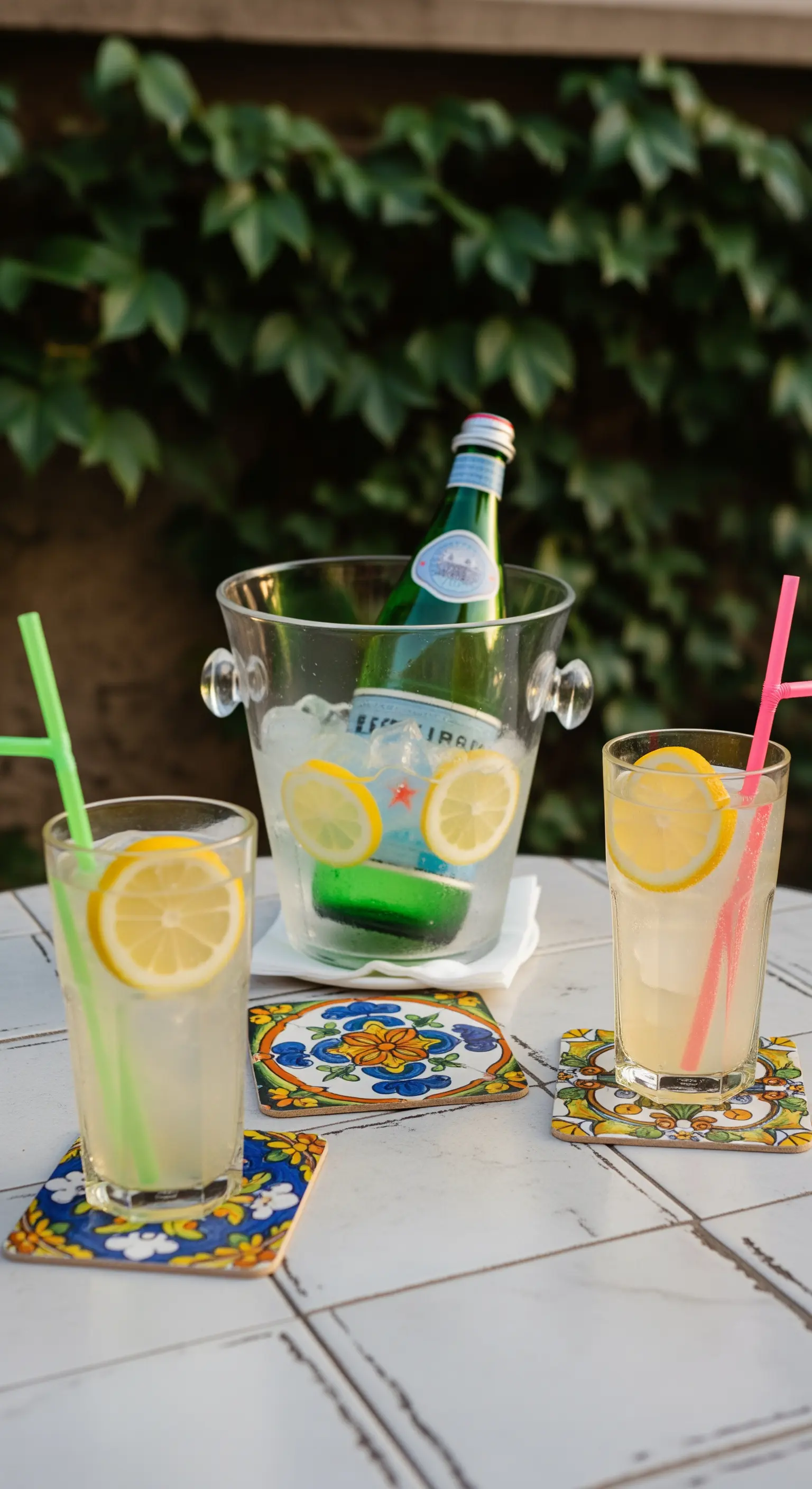 Wassergläser mit Zitrone und Flasche im Eiskühler