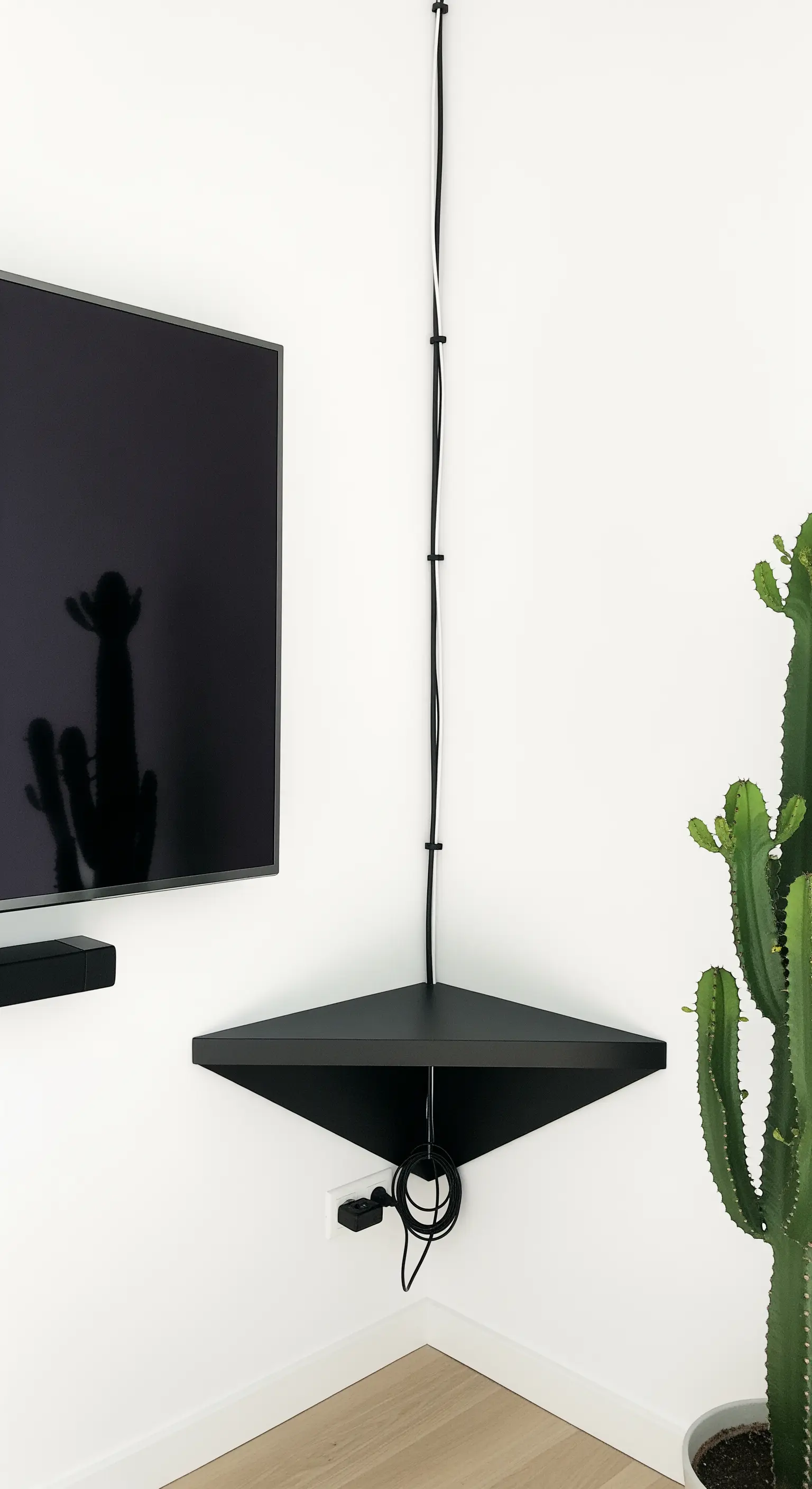 TV in der Ecke mit schwarzem Eckregal