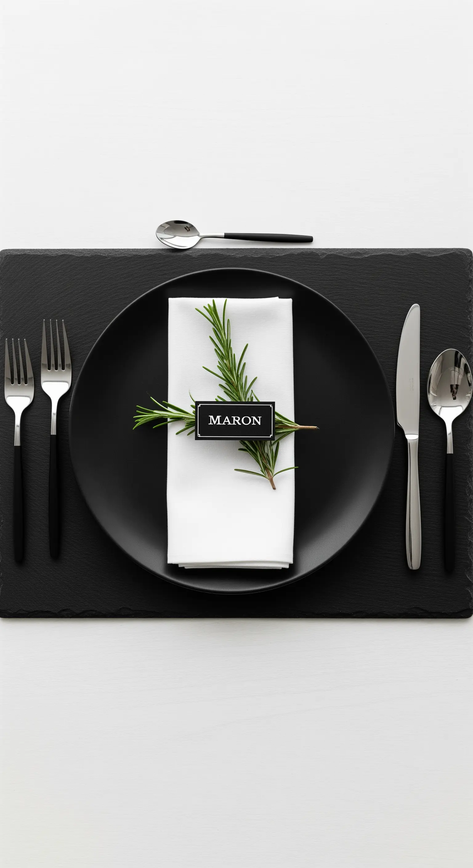 Schwarzer Teller mit weißer Serviette, Rosmarinzweig und schwarzem Namensschild