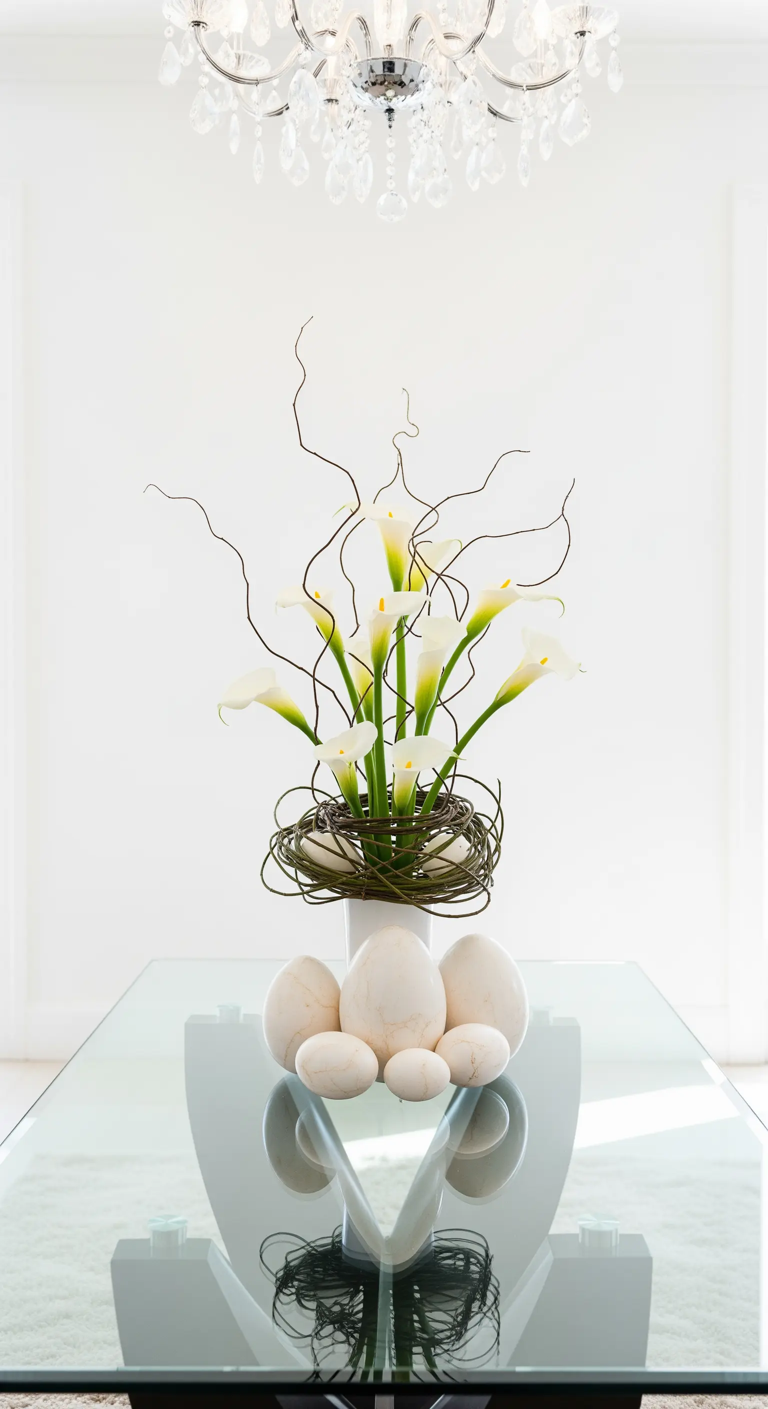 Glastisch mit Calla-Lilien und Marmoreiern