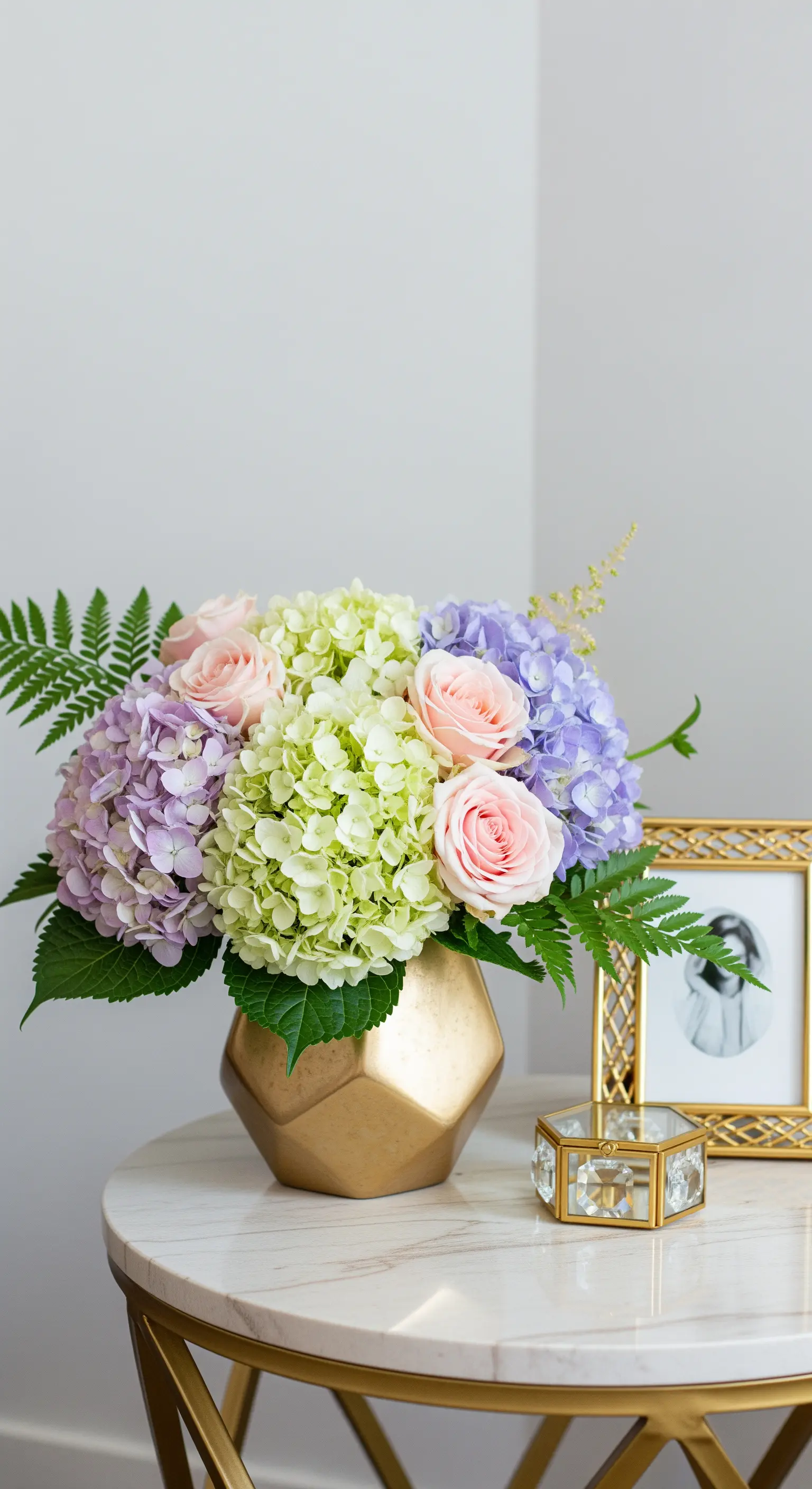 Goldene geometrische Vase mit Hortensien auf Marmortisch