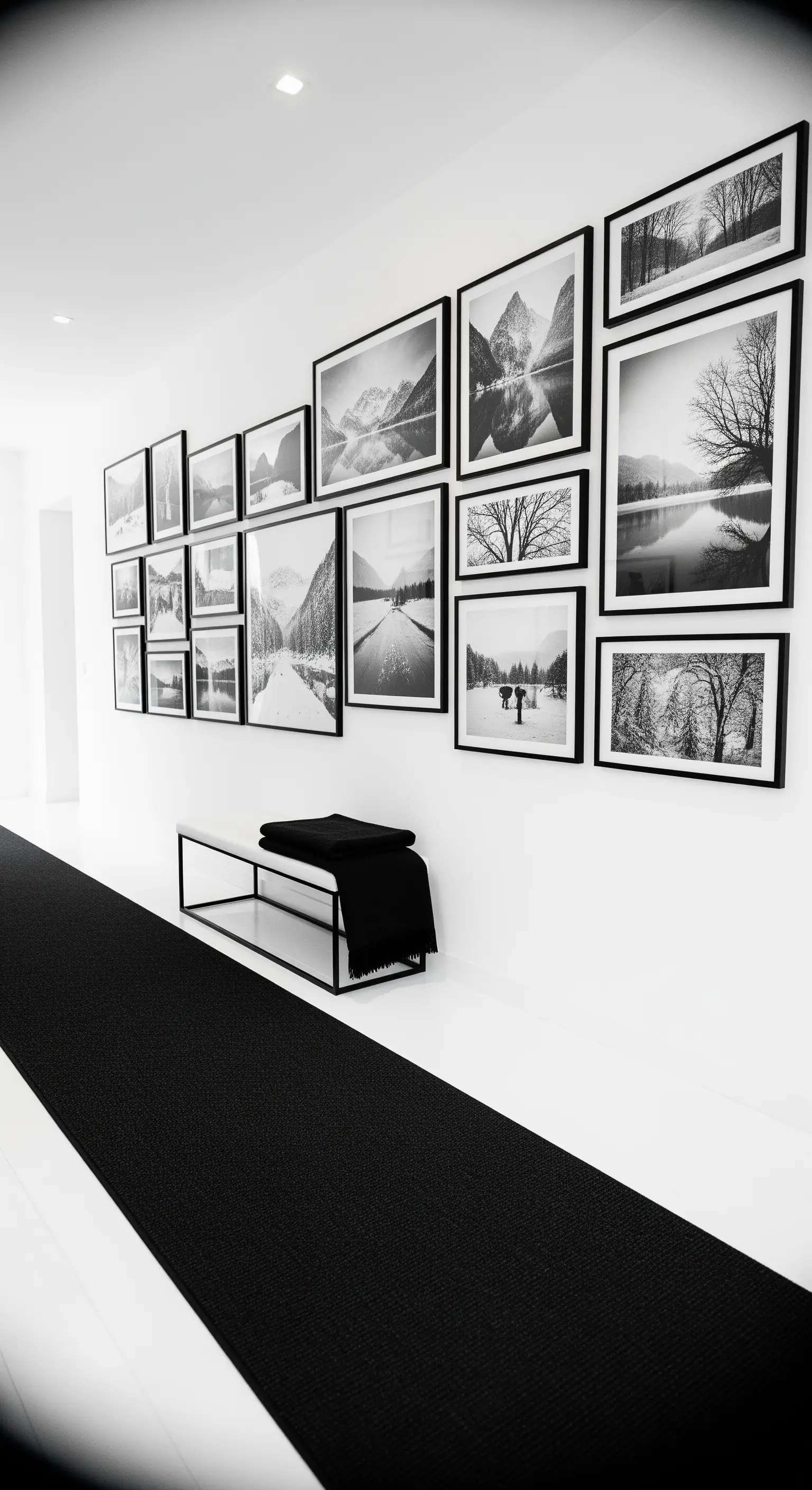 Langer weißer Flur mit Galerie-Wand aus schwarz-weißen Landschaftsfotos
