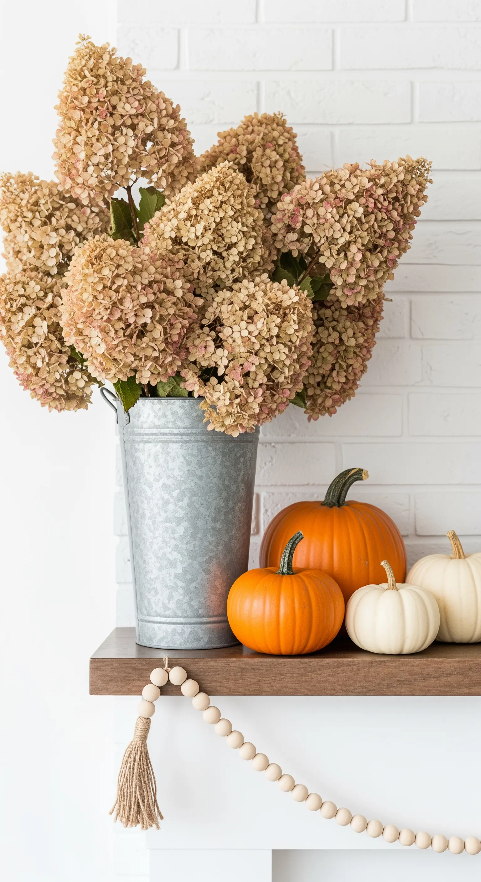 Trockenblumen Hortensien in Zinkeimer auf Kaminsims