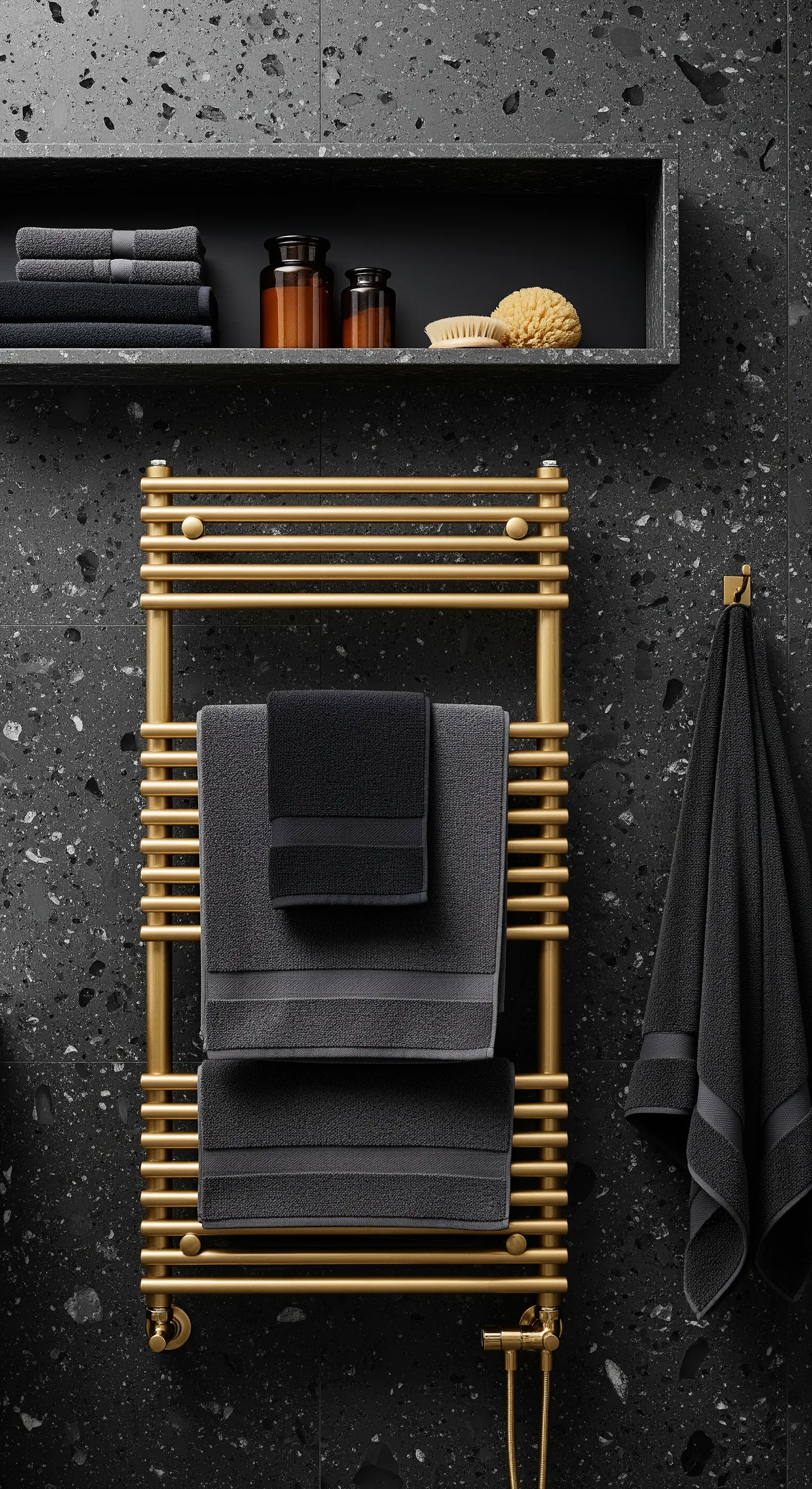 Goldener Handtuchheizkörper an schwarzer Terrazzowand