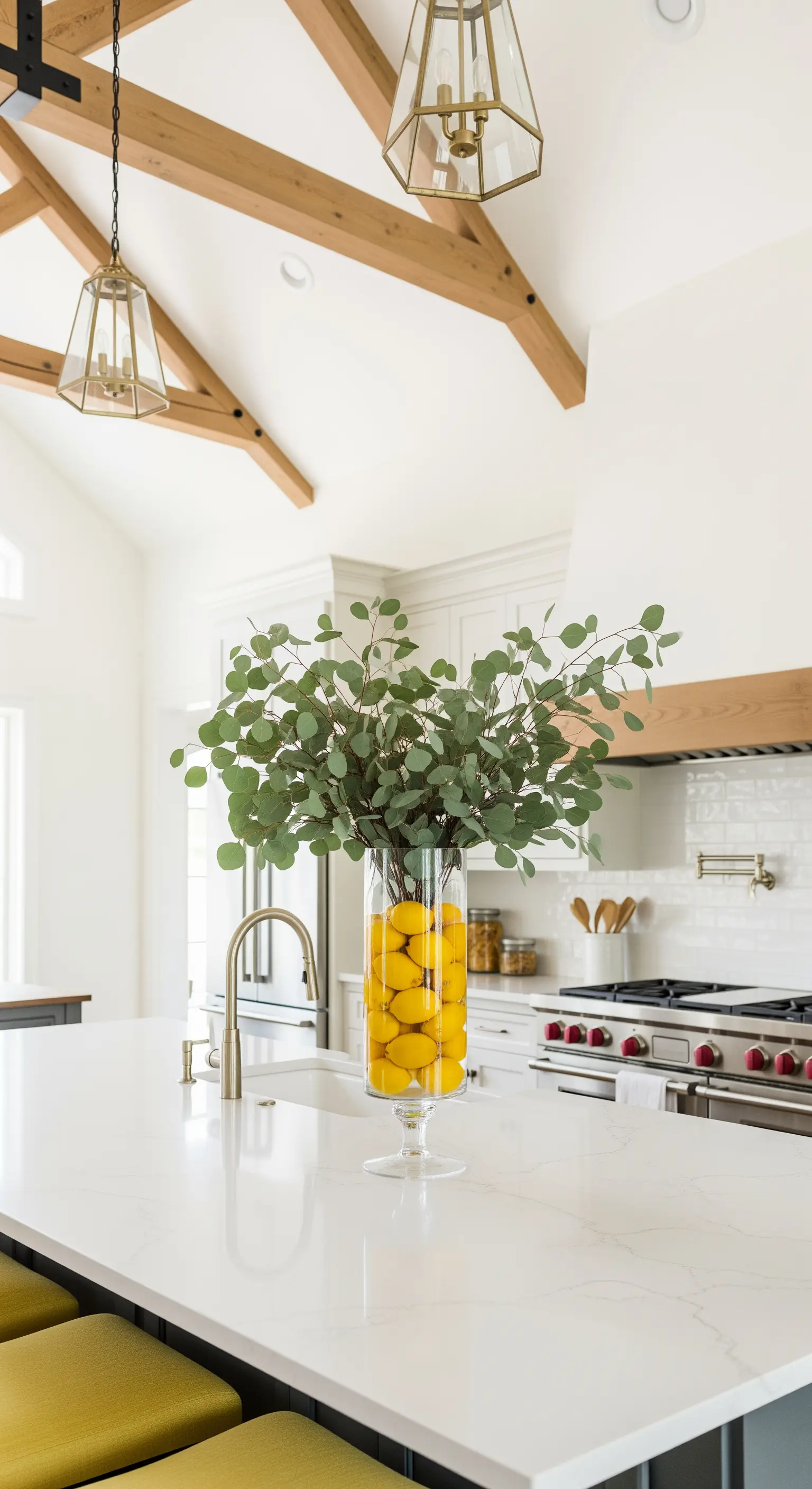 Hohe Glasvase mit Zitronen und Eukalyptus auf Kücheninsel