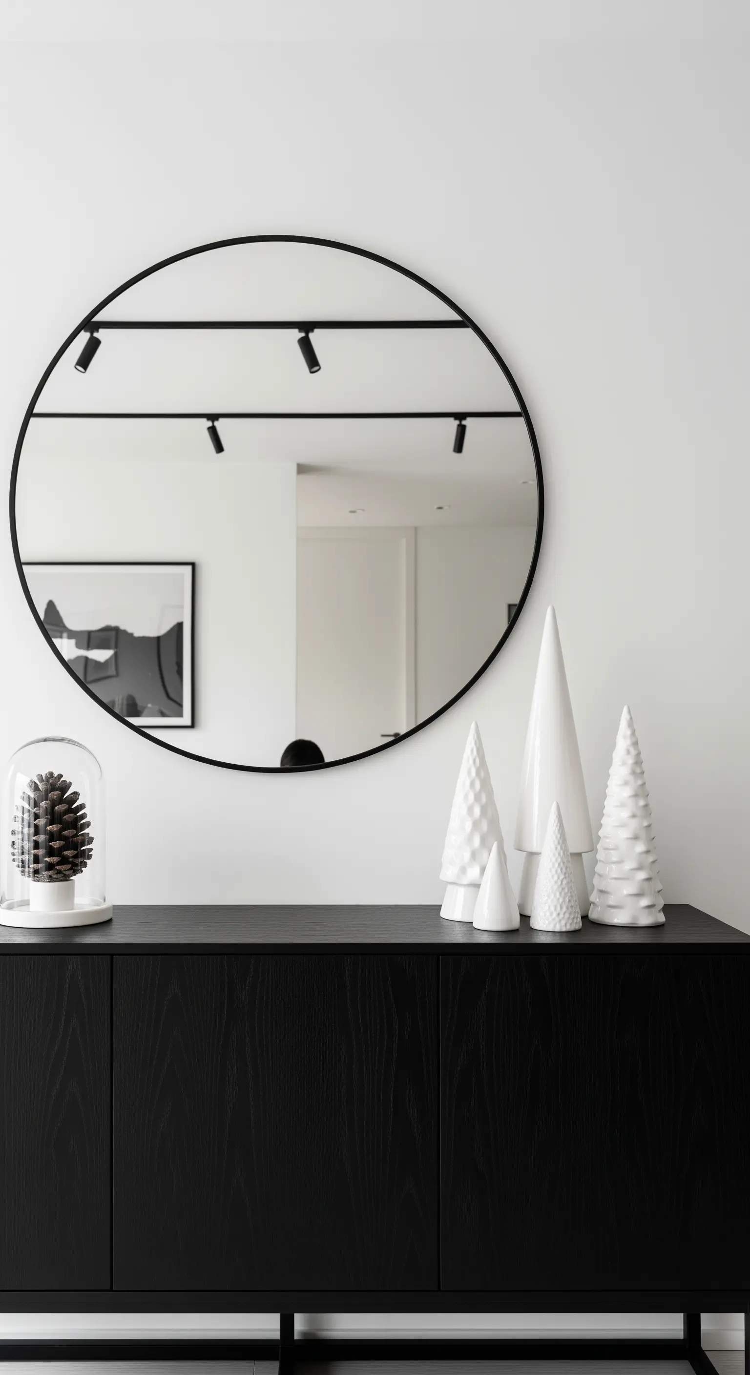 Schwarzes Sideboard mit weißen Keramik-Tannenbäumen und rundem Spiegel