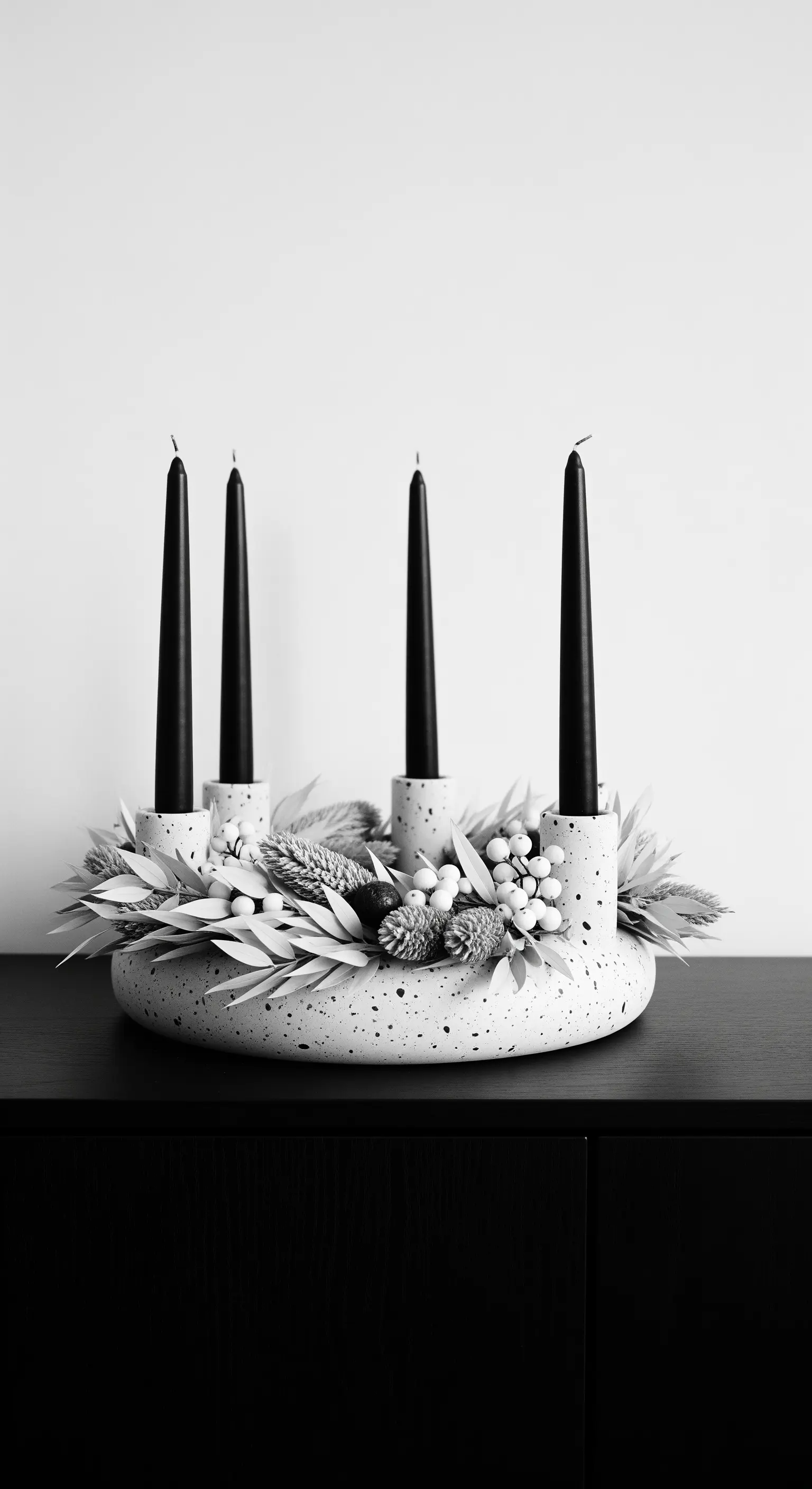 Weißer Terrazzo-Ringhalter mit schwarzen Stabkerzen und weißer Trockendeko