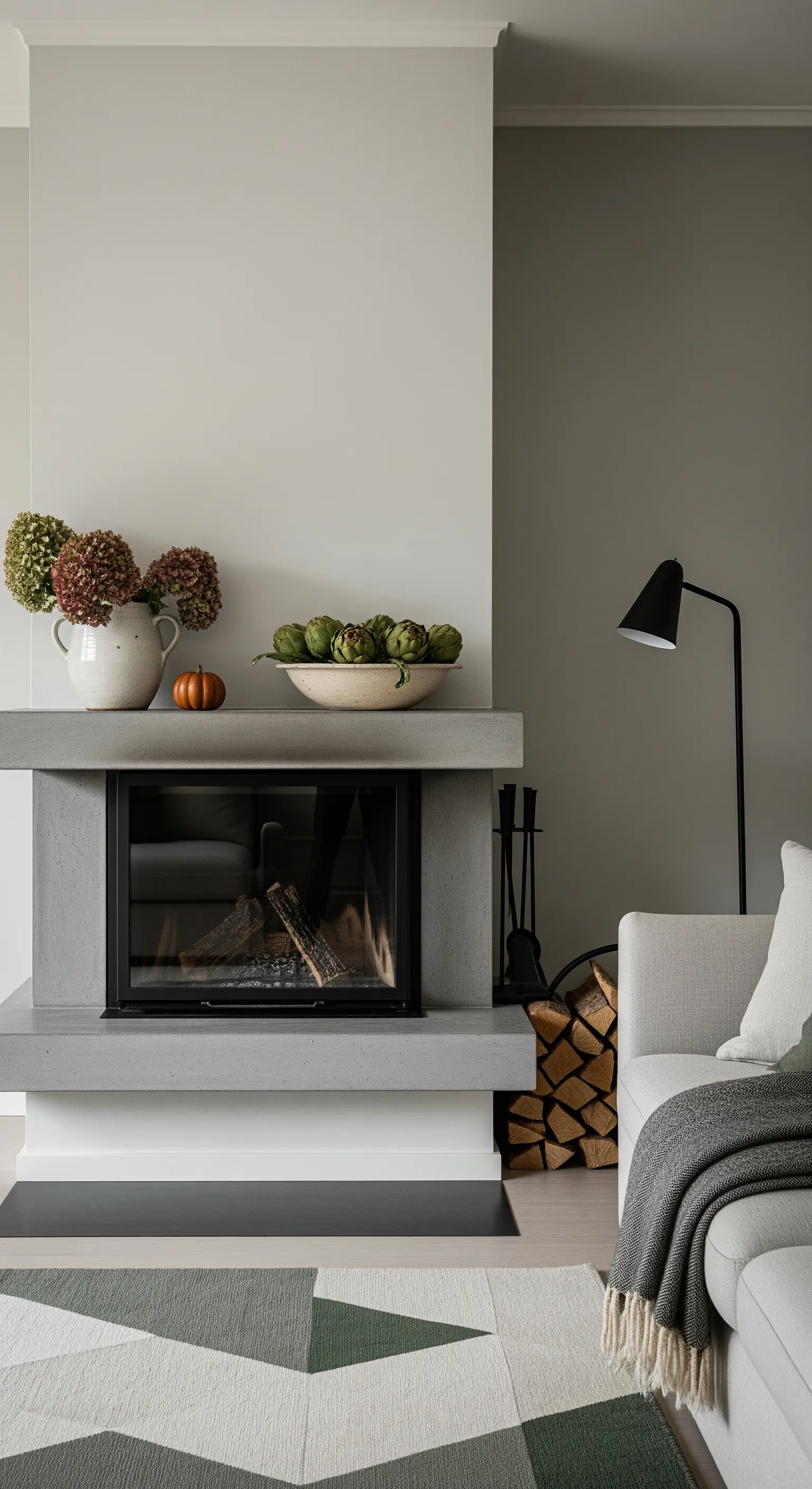 Betonkamin mit Hortensienvase und Schale voller Artischocken