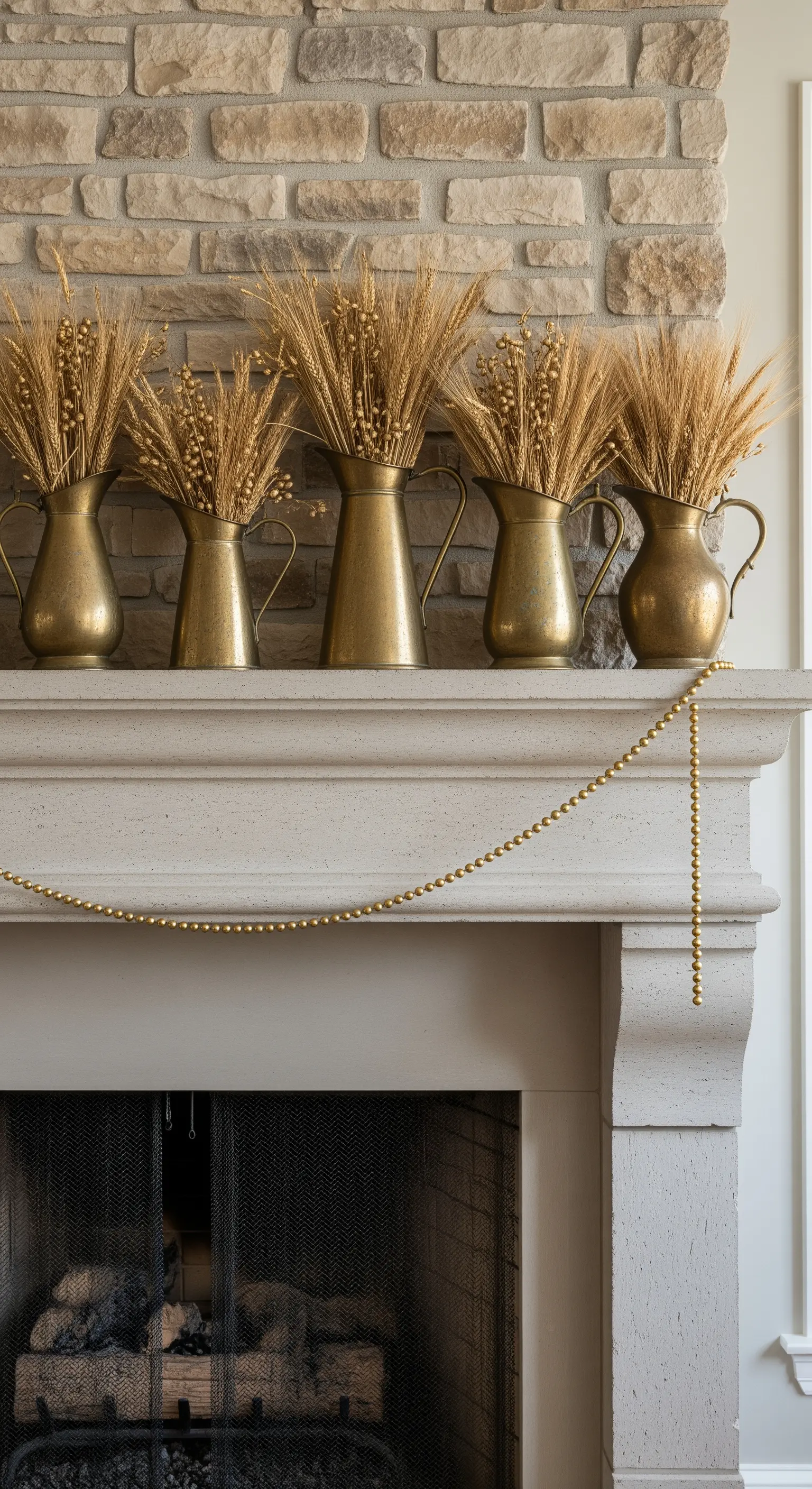 Steinkamin mit einer Reihe von Messingkrügen, gefüllt mit Weizenähren und einer Perlenkette.