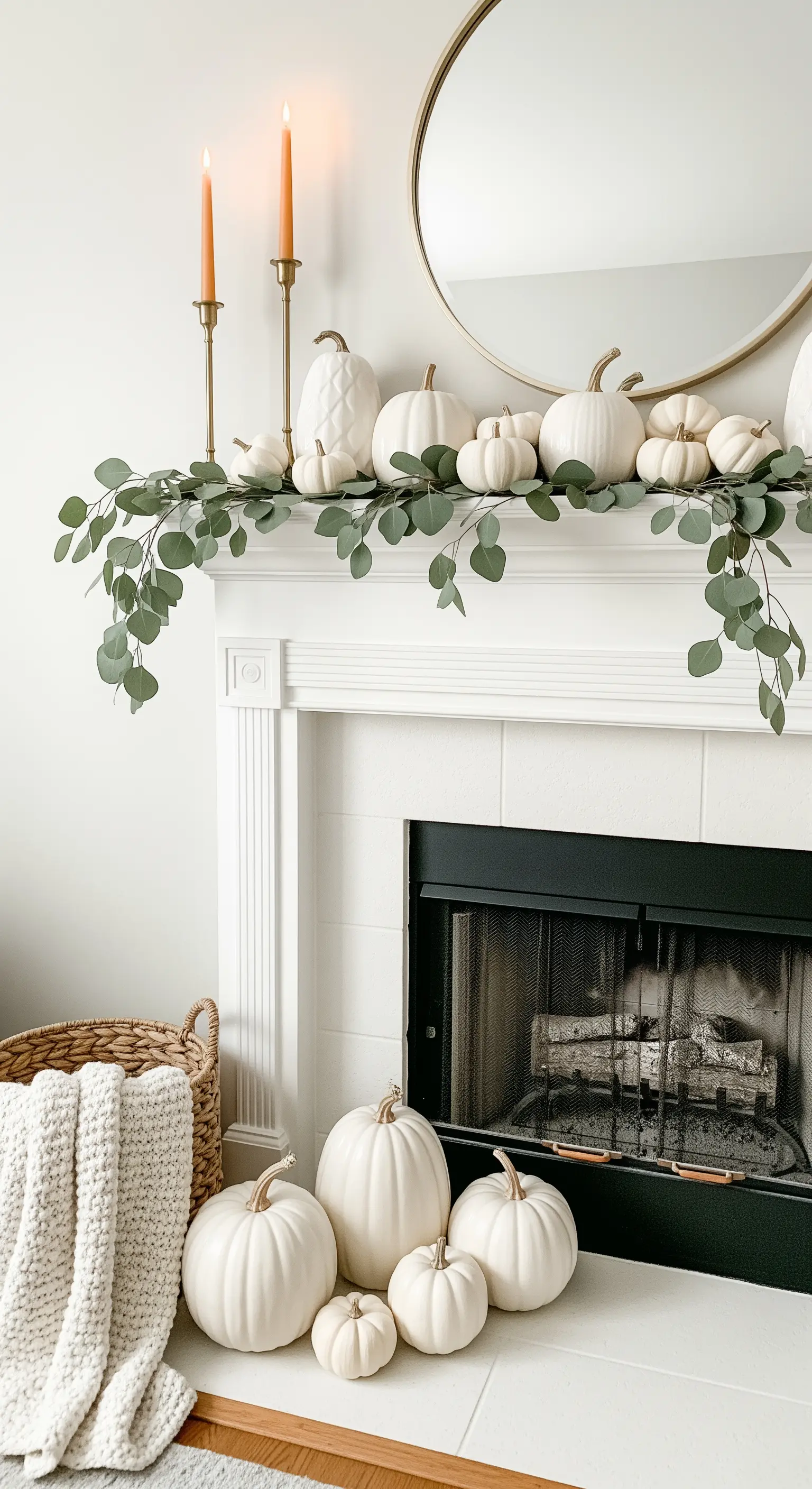 Weiße Kürbisse und Eukalyptusgirlande auf weißem Kamin