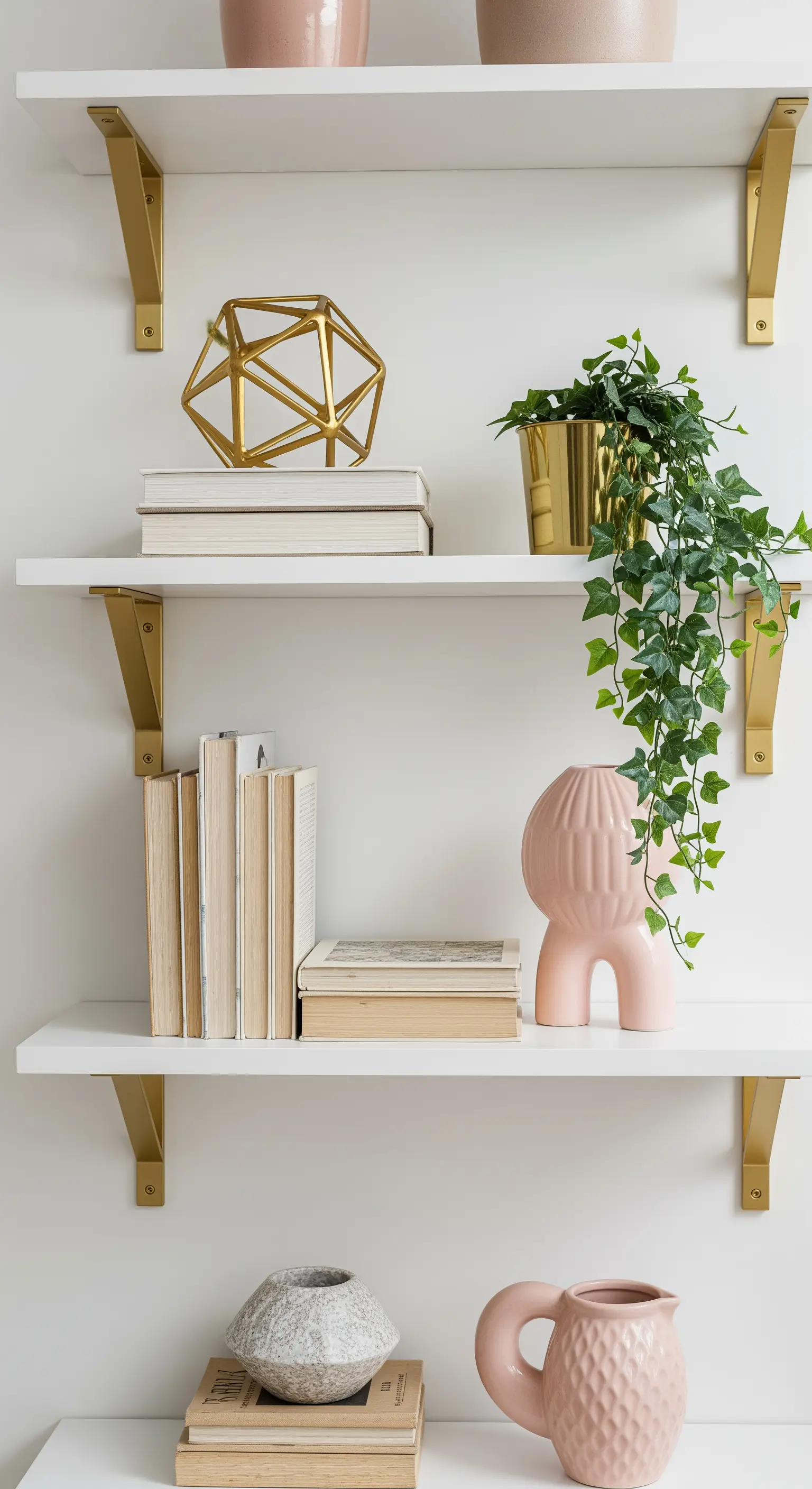 Weißes Regal mit Goldträgern und Efeupflanze