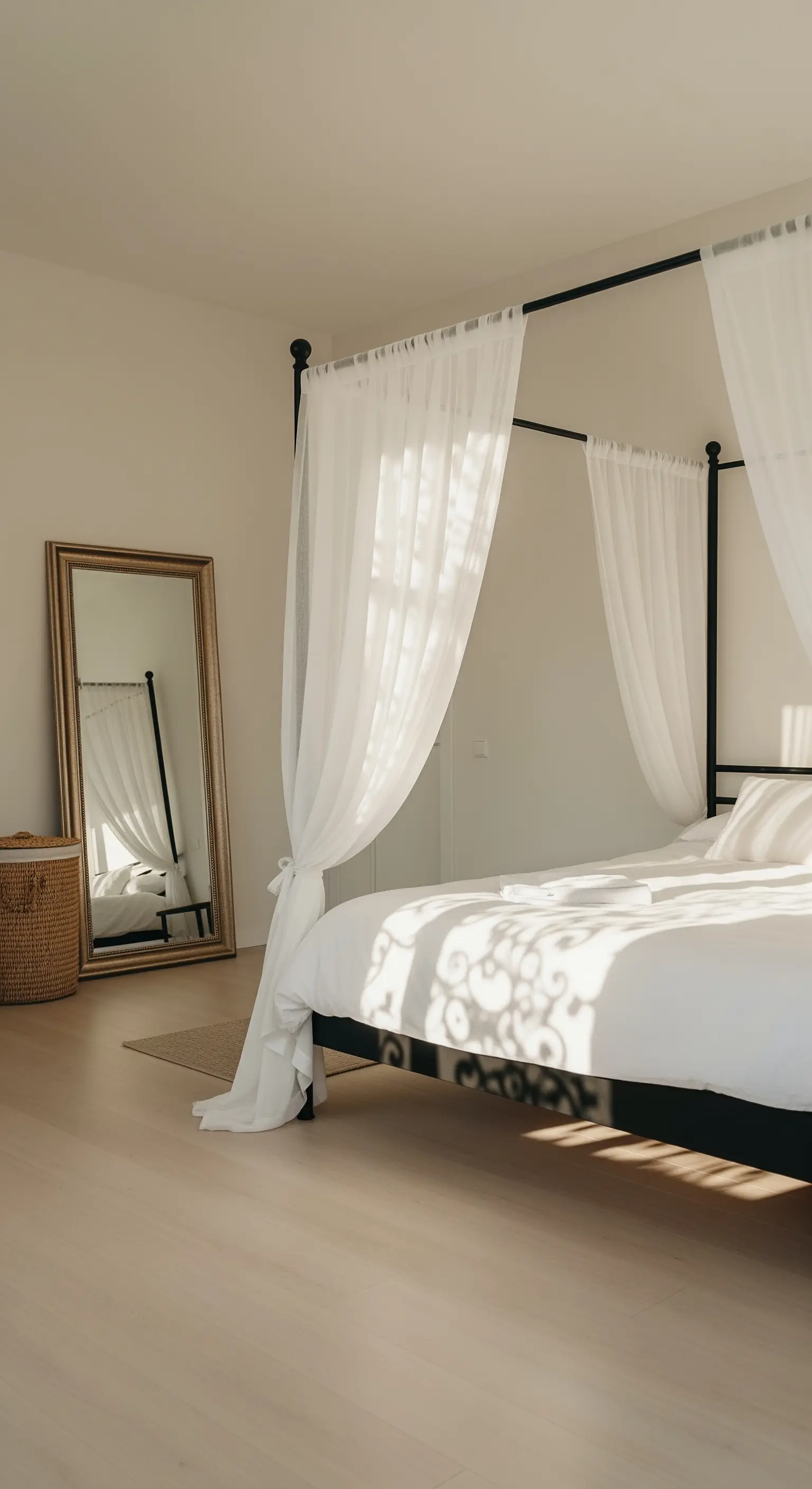 Schwarzes Himmelbett mit weißen, leichten Vorhängen