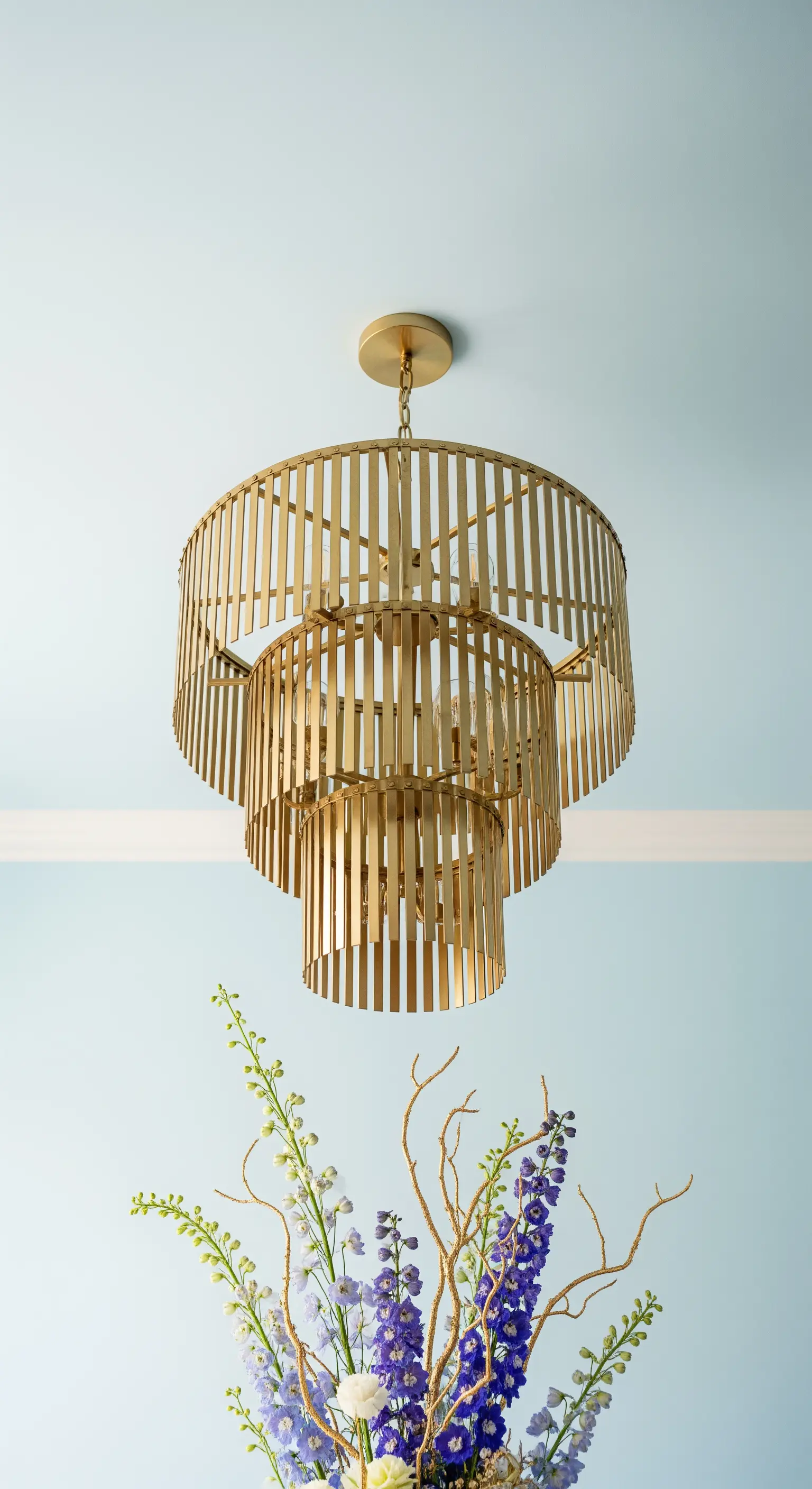 Goldener Art-Deco Kronleuchter vor blauer Wand