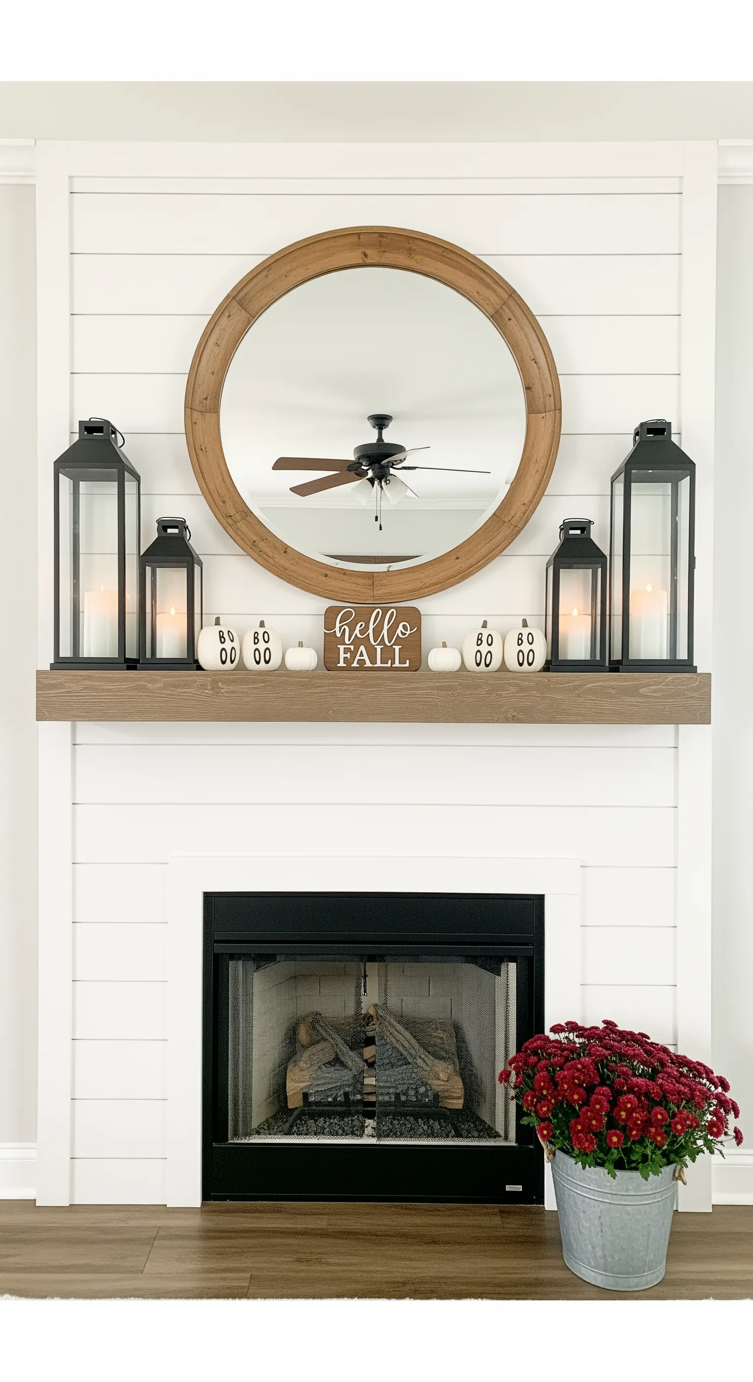 Symmetrische Kamin-Deko mit schwarzen Laternen und Herbst-Schild