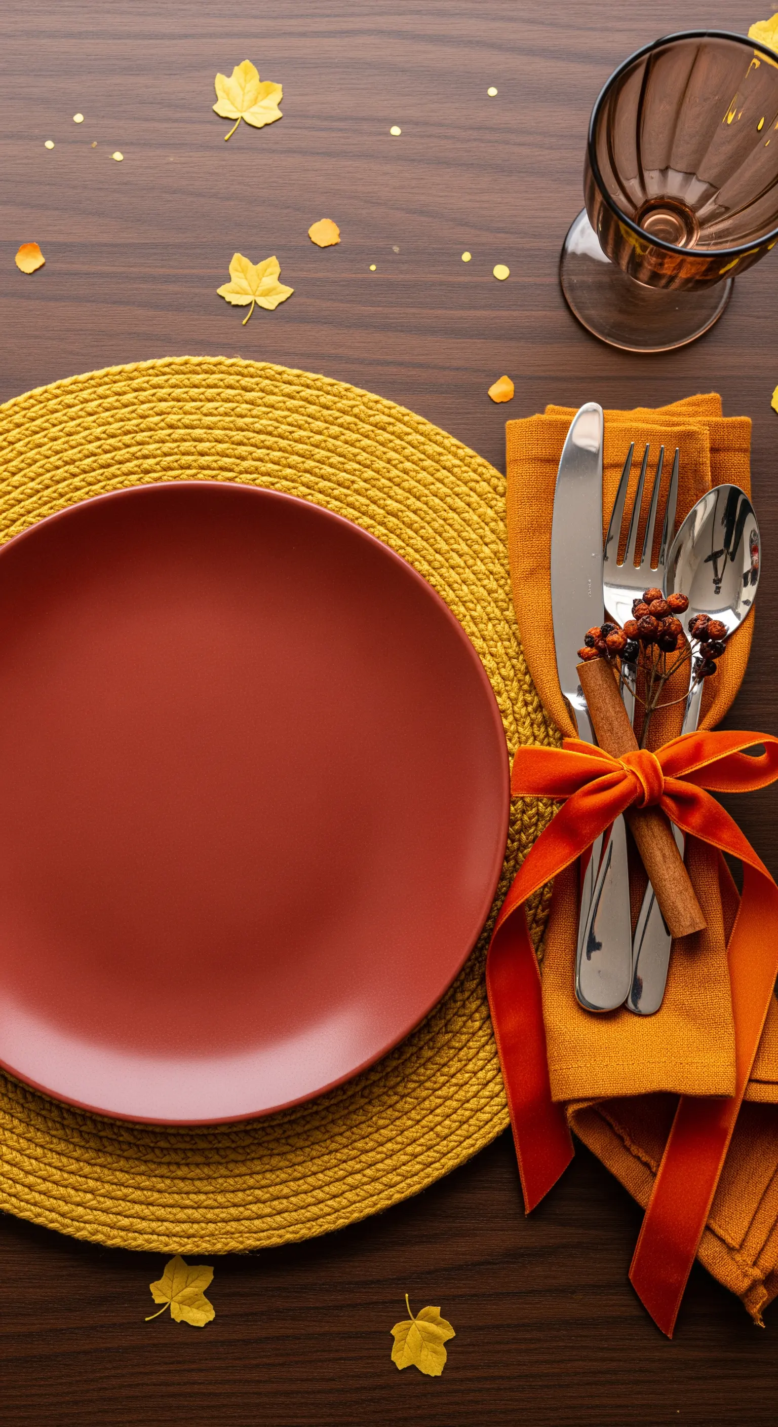 Roter Teller auf gelbem Platzset mit Besteck und Samtschleife