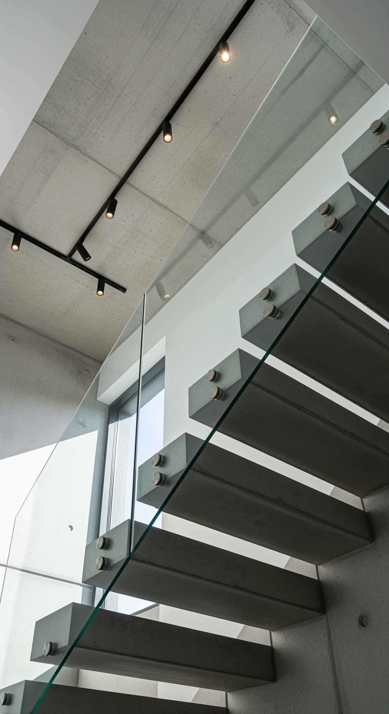 Treppe mit schwebenden Betonstufen und Glasgeländer