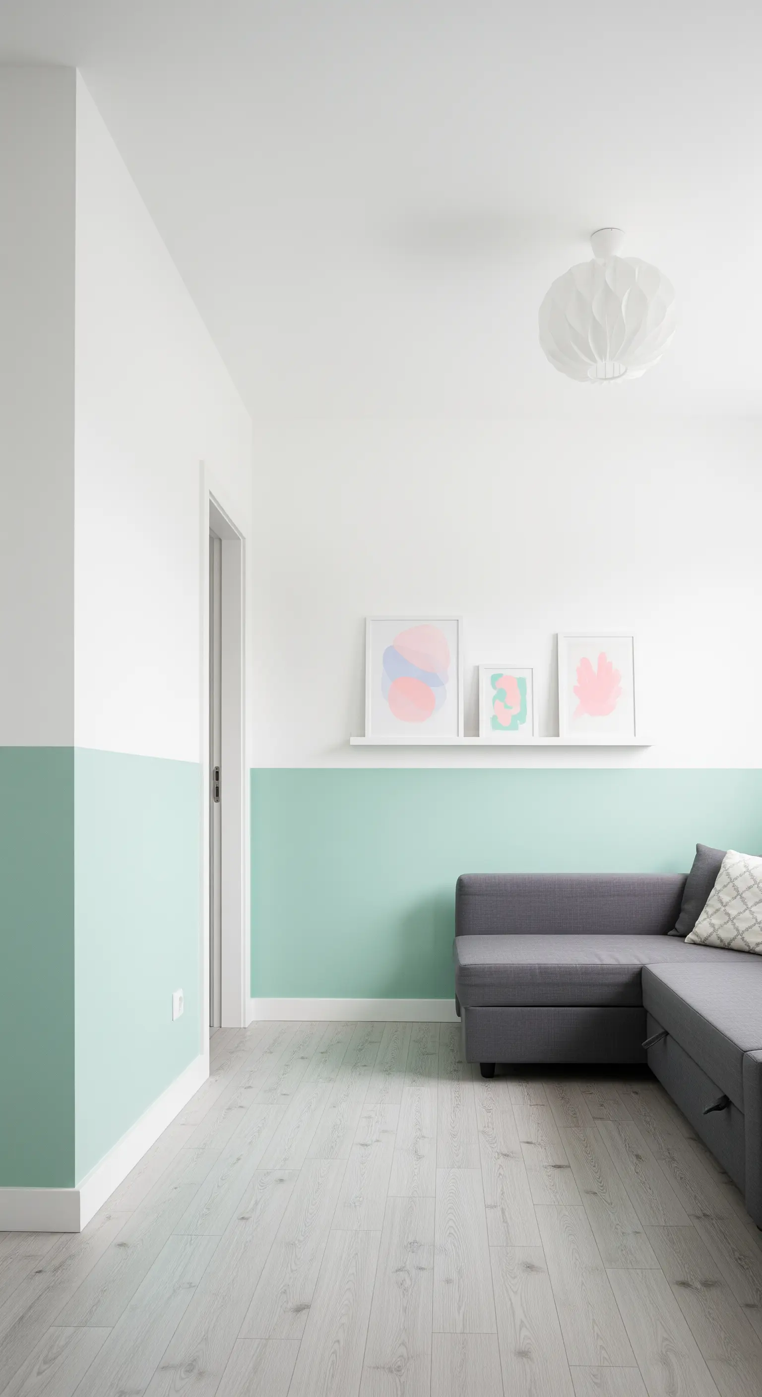 Wand halbhoch mintgrün gestrichen mit grauem Sofa