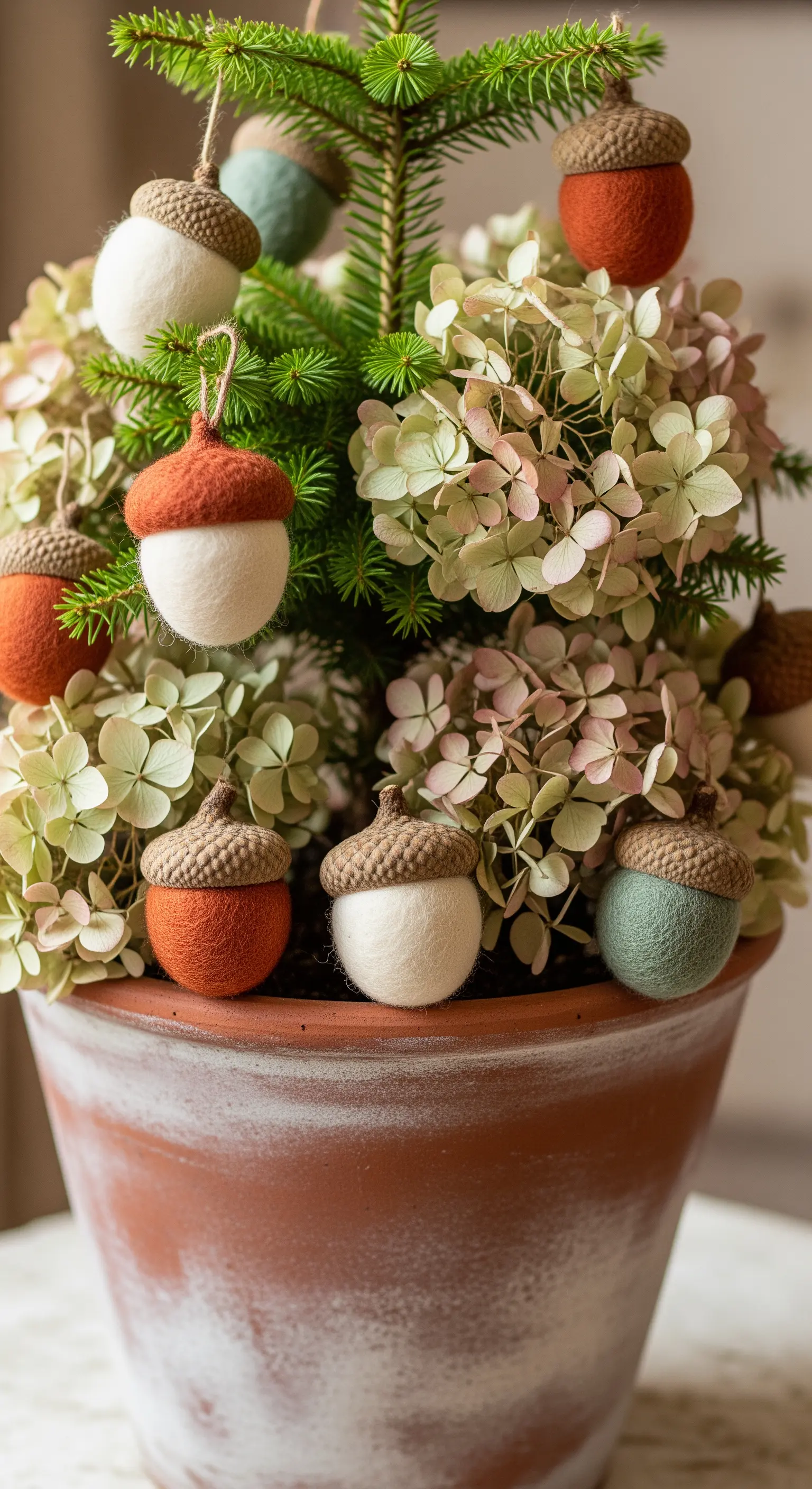 Topfpflanze mit Filz-Eichel-Ornamenten in Naturfarben und echten Eichelkappen.