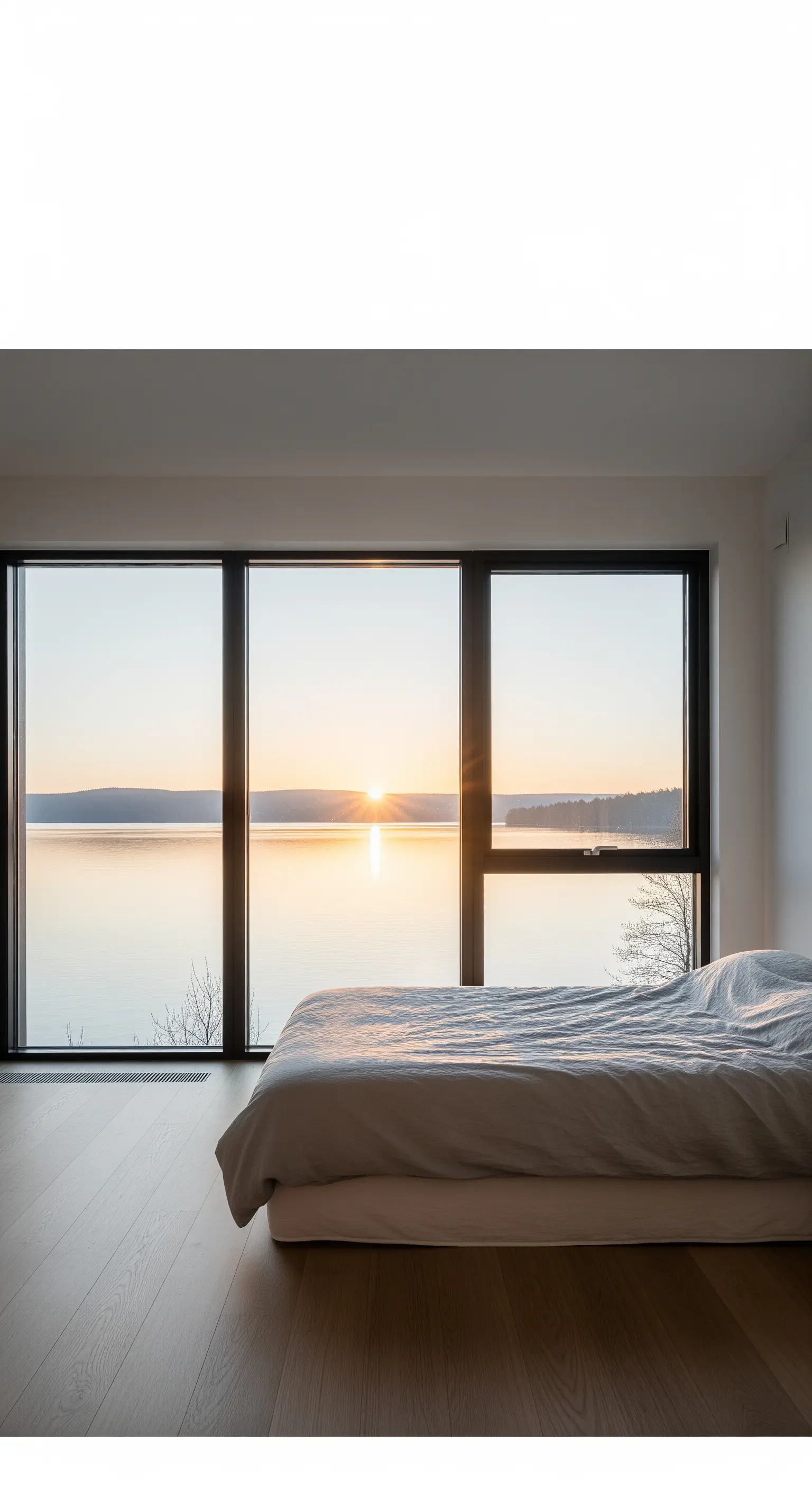 Ein Bett mit direktem Blick auf einen See bei Sonnenaufgang für ein natürliches Erwachen.