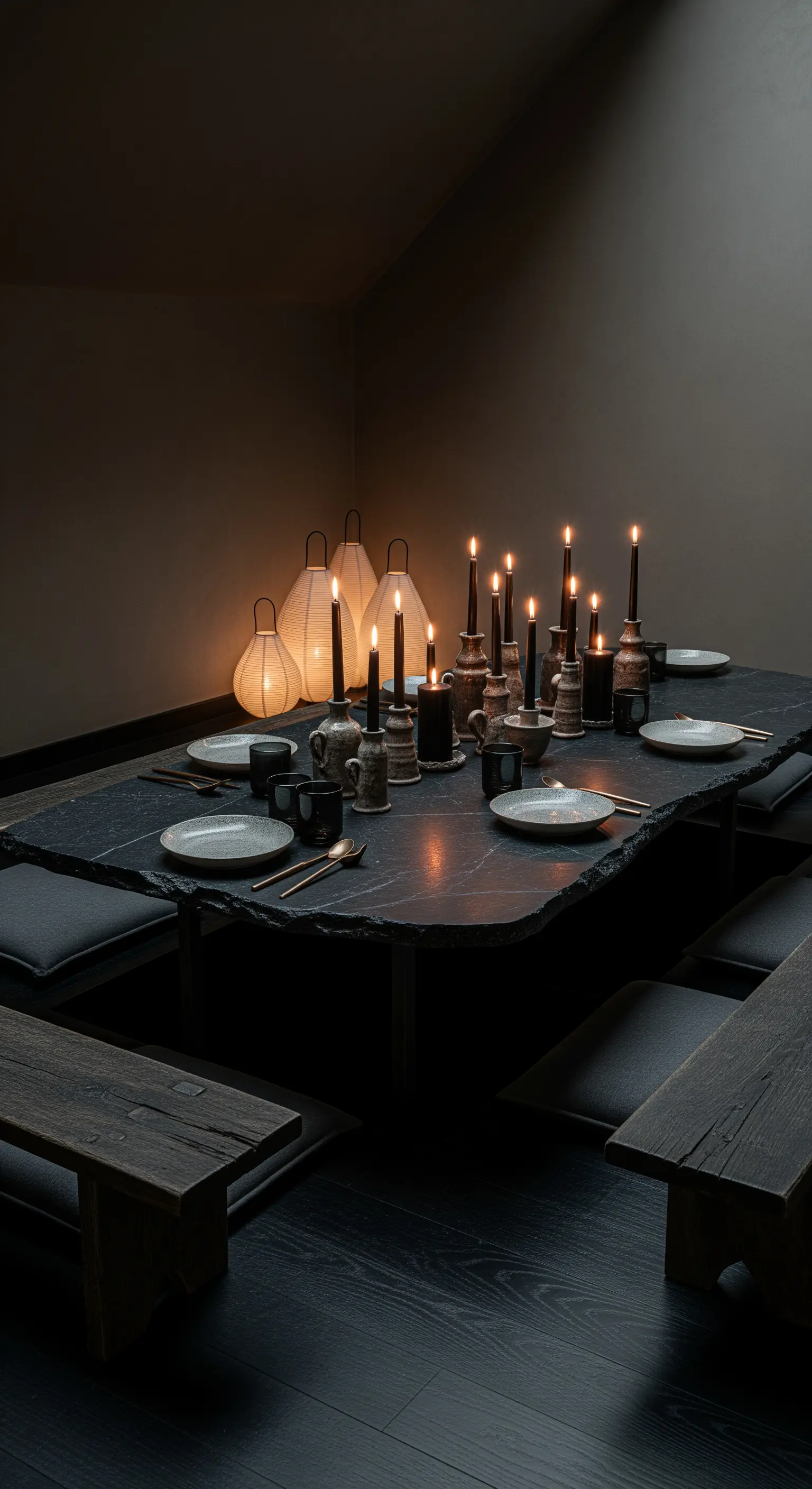 Intime Tischszene mit Kerzen und Laternen auf einem niedrigen Steintisch.