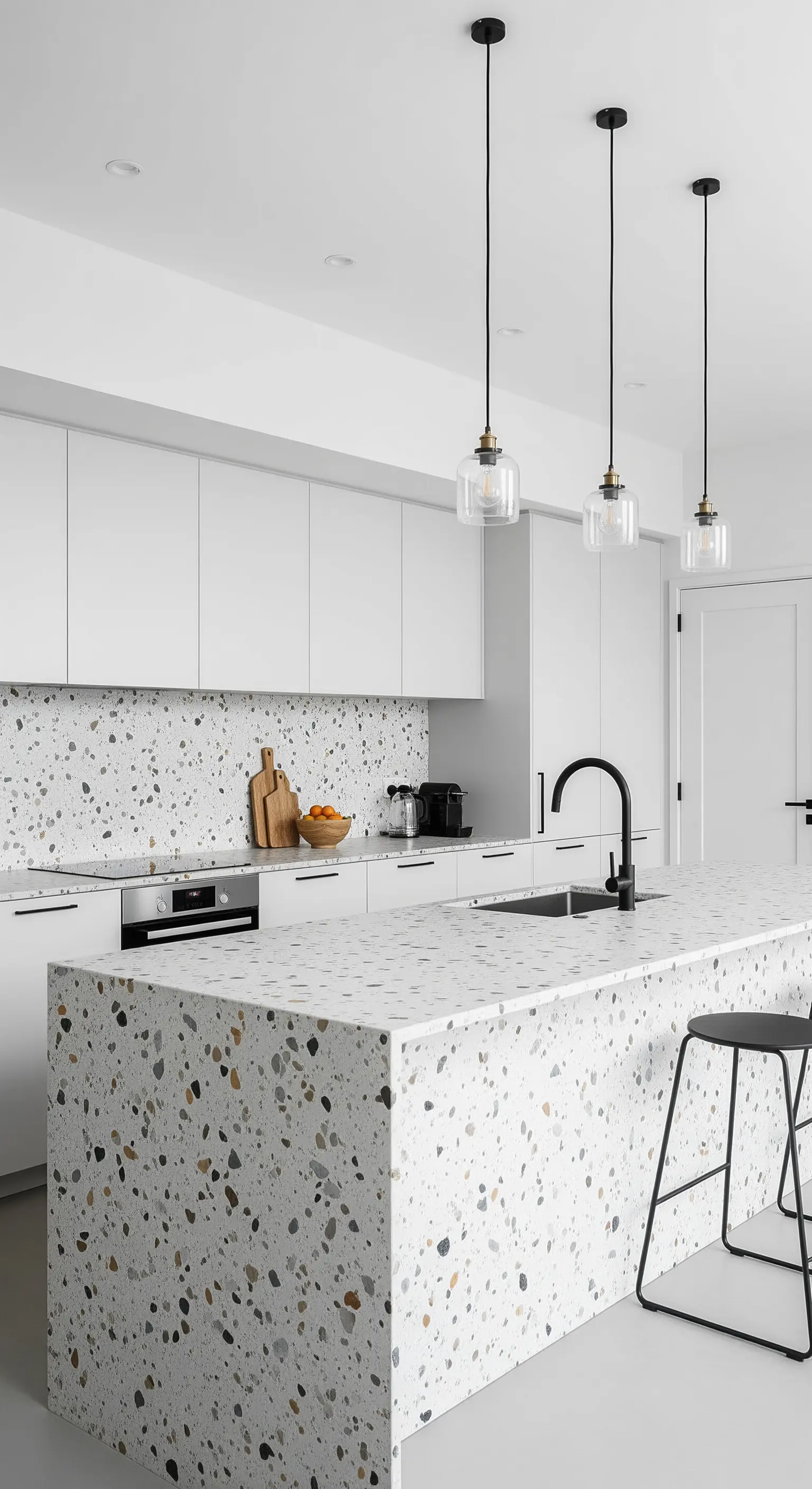 Moderne, weiße Küche mit einer dominanten Kücheninsel aus Terrazzo.