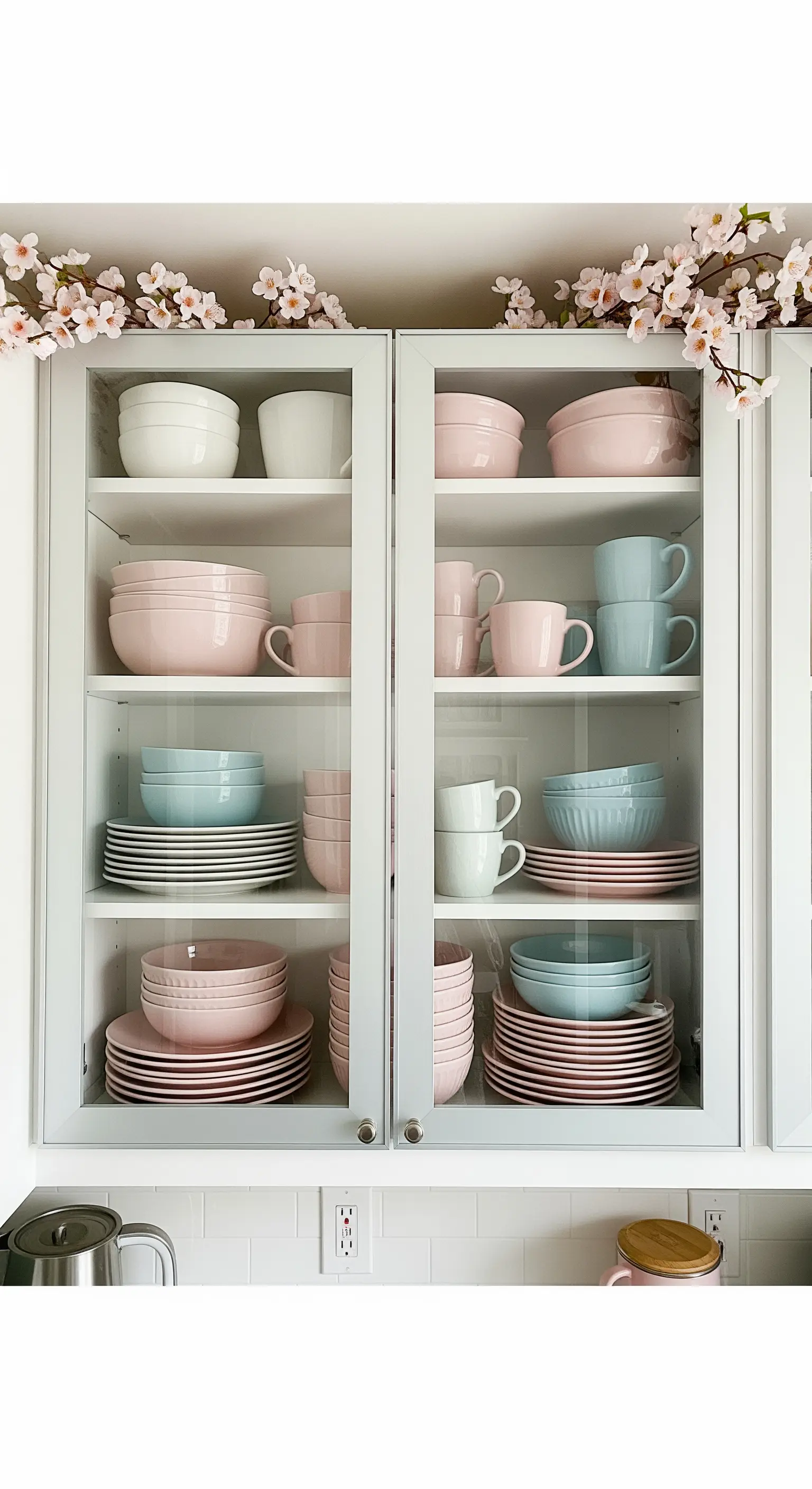 Vitrinenschrank gefüllt mit sorgfältig sortiertem rosa und hellblauem Geschirr