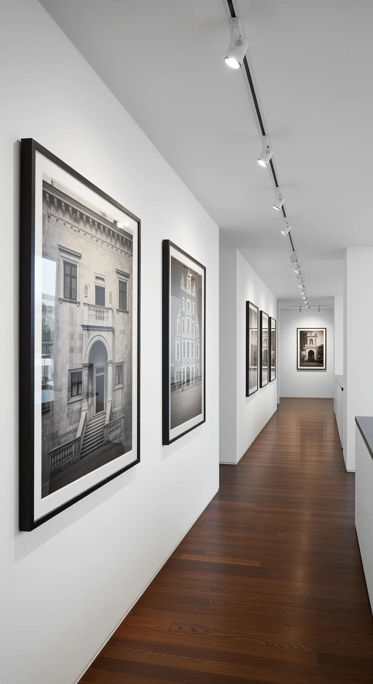 Langer Flur, der mit großen Schwarz-Weiß-Fotografien wie eine Galerie gestaltet ist.