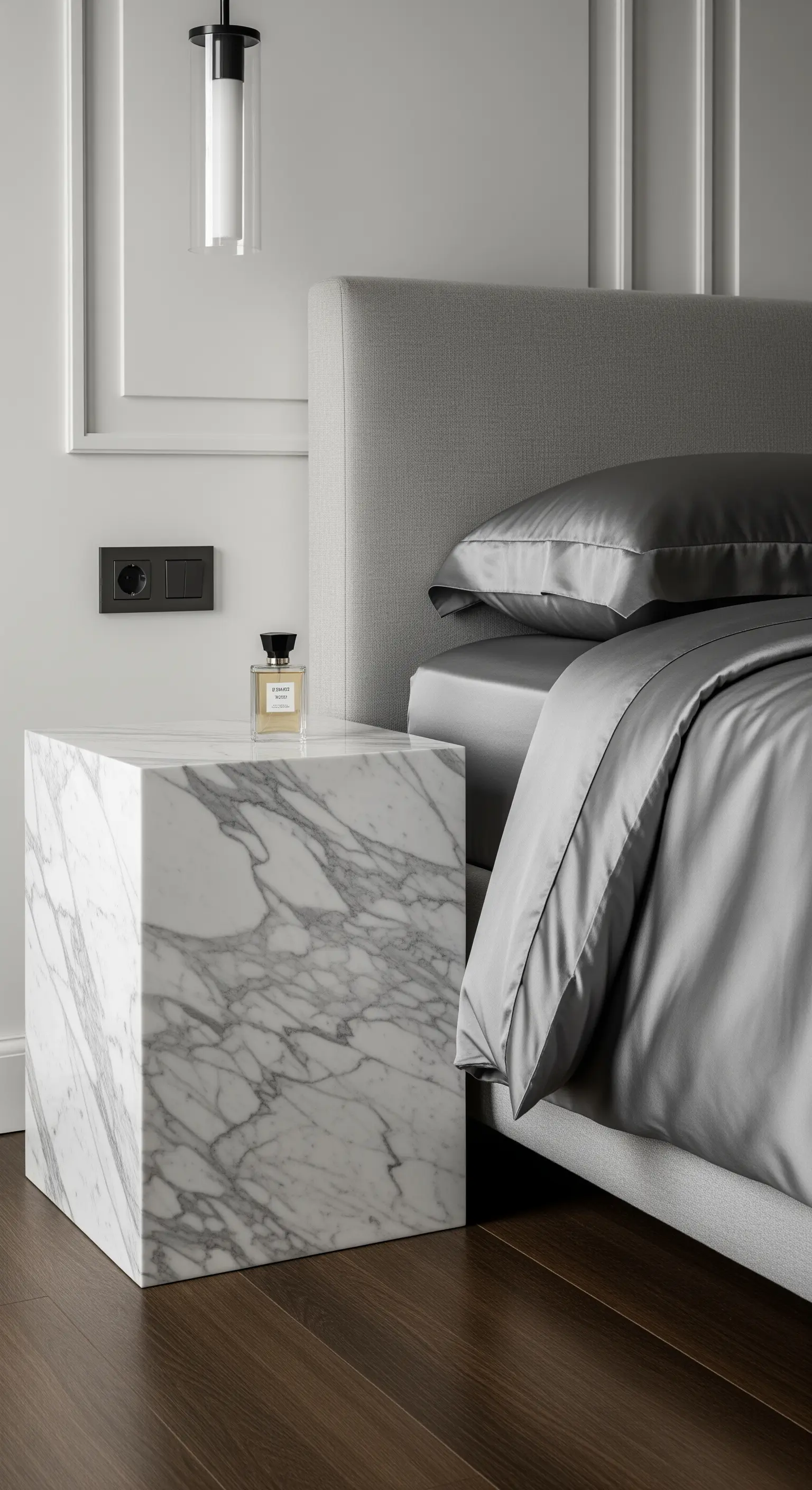 Massiver Marmorblock als luxuriöser Nachttisch neben einem Bett mit Seidenbezug.