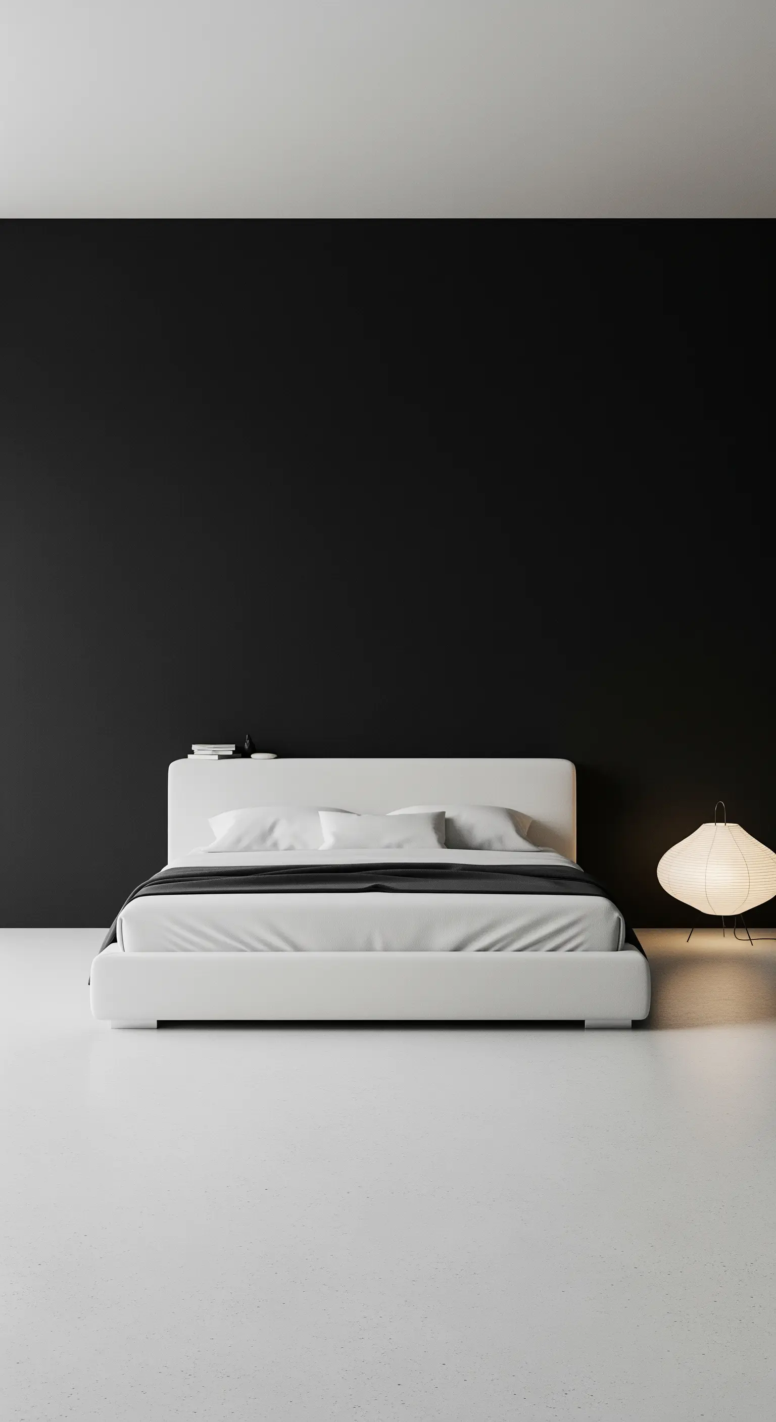 Minimalistisches Schlafzimmer mit schwarzer Wand, weißem Bett und einer Bodenleuchte.