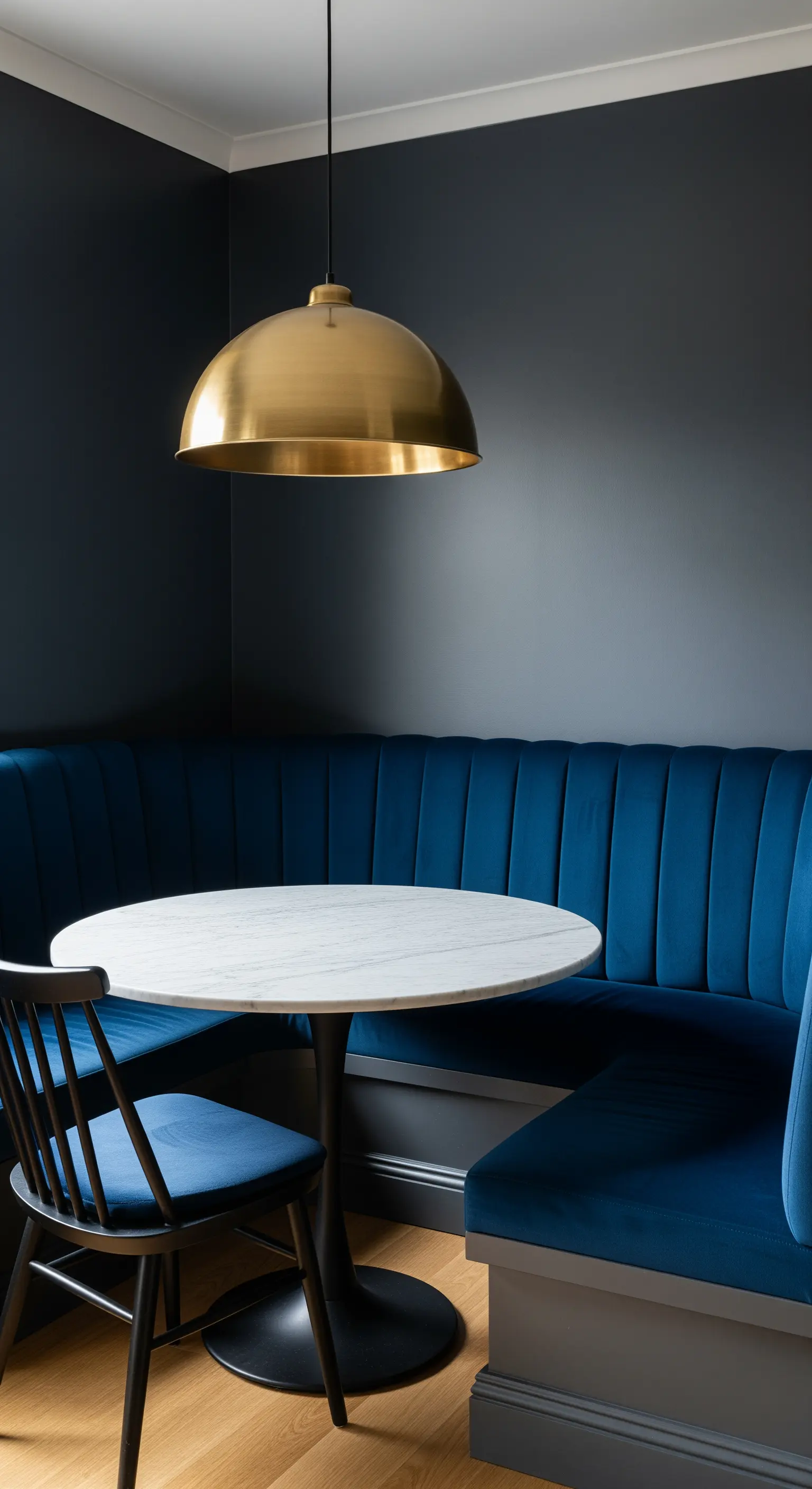 Essnische mit einer gepolsterten Sitzbank aus blauem Samt und einer goldenen Hängelampe