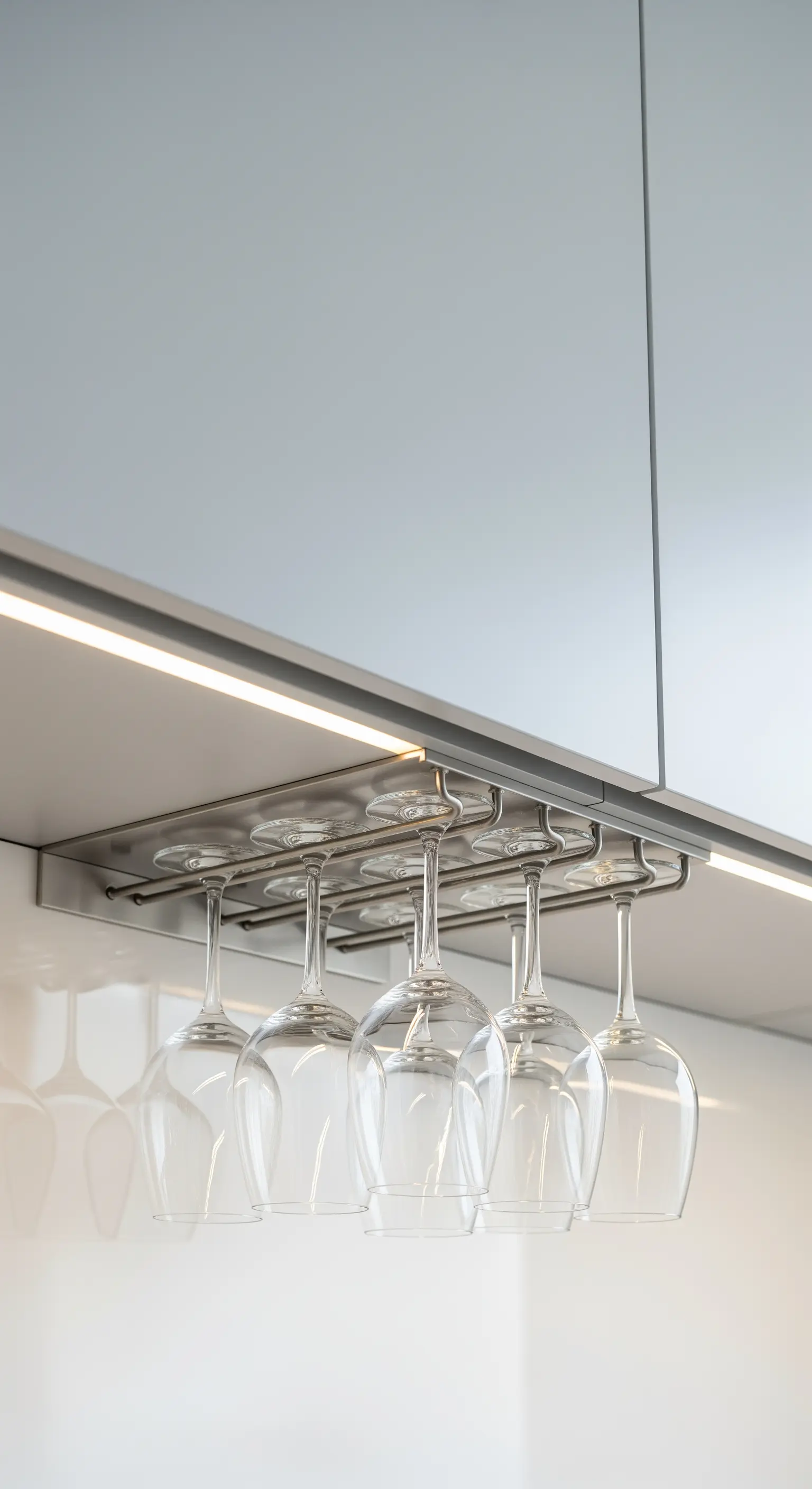 Weingläser hängen kopfüber in einem Halter unter einem Küchenoberschrank.