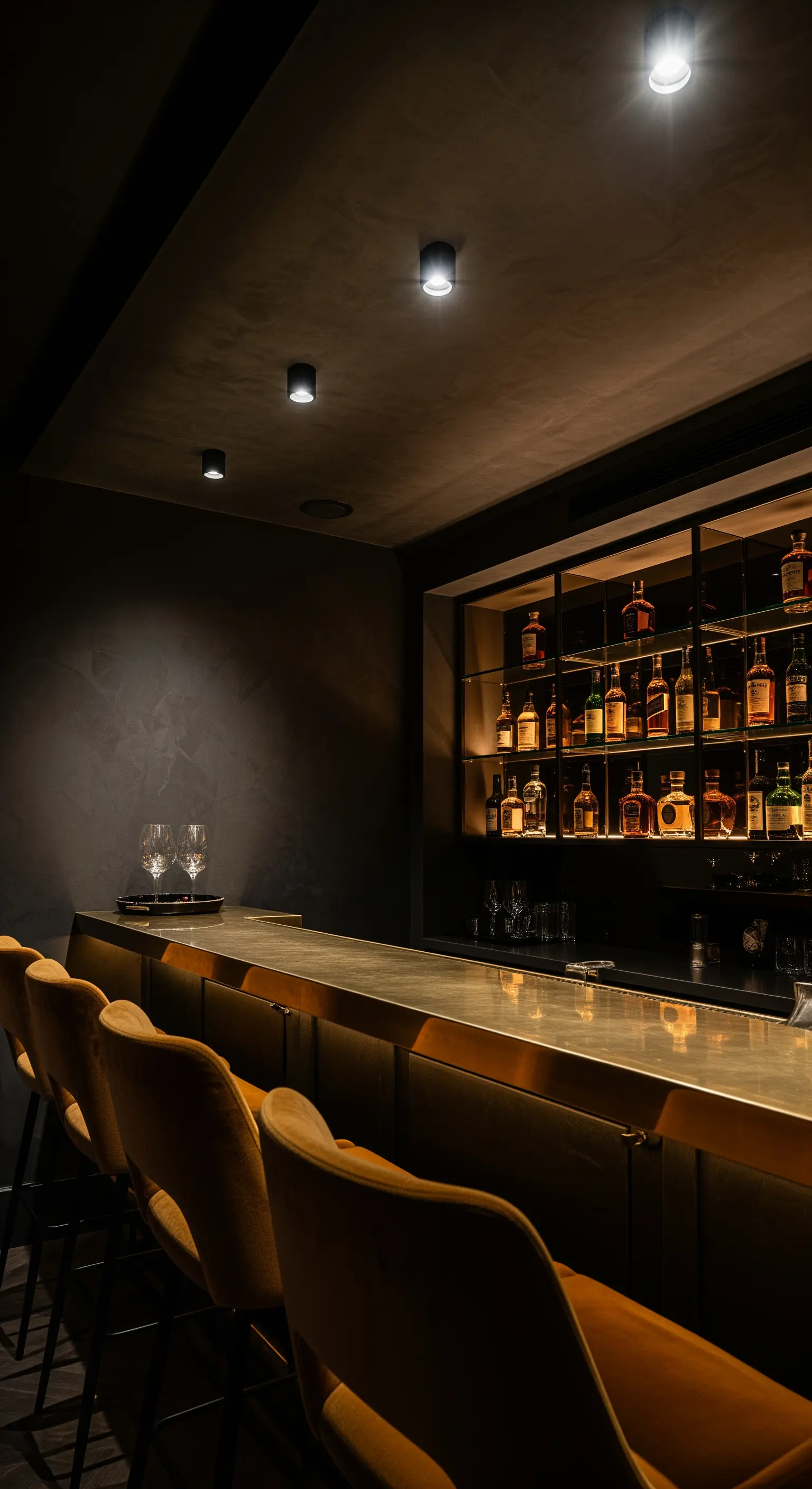 Dunkle Hausbar mit einer Theke aus Messing und senfgelben Samt-Barhockern