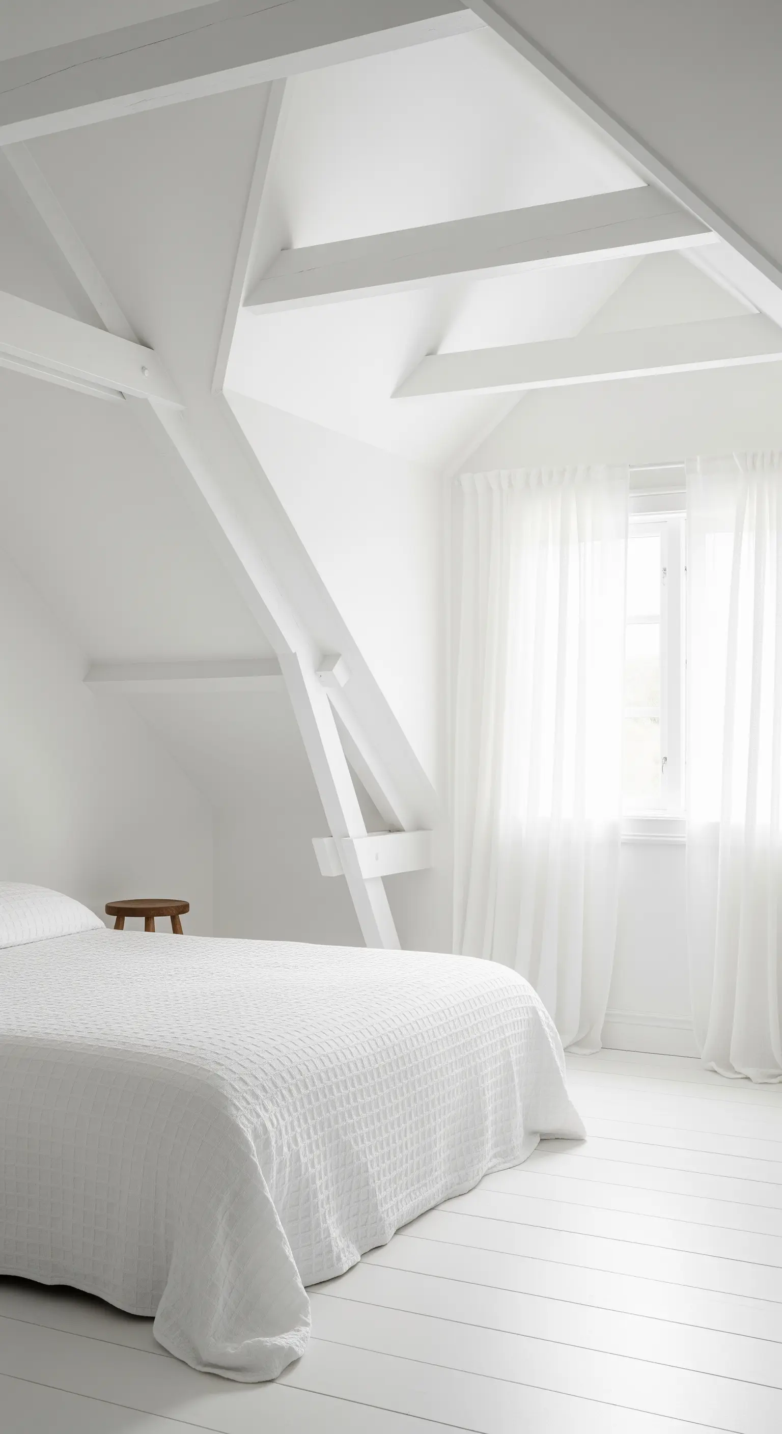 Komplett weißes Schlafzimmer mit weiß gestrichenen Böden und Deckenbalken sowie leichten Vorhängen.