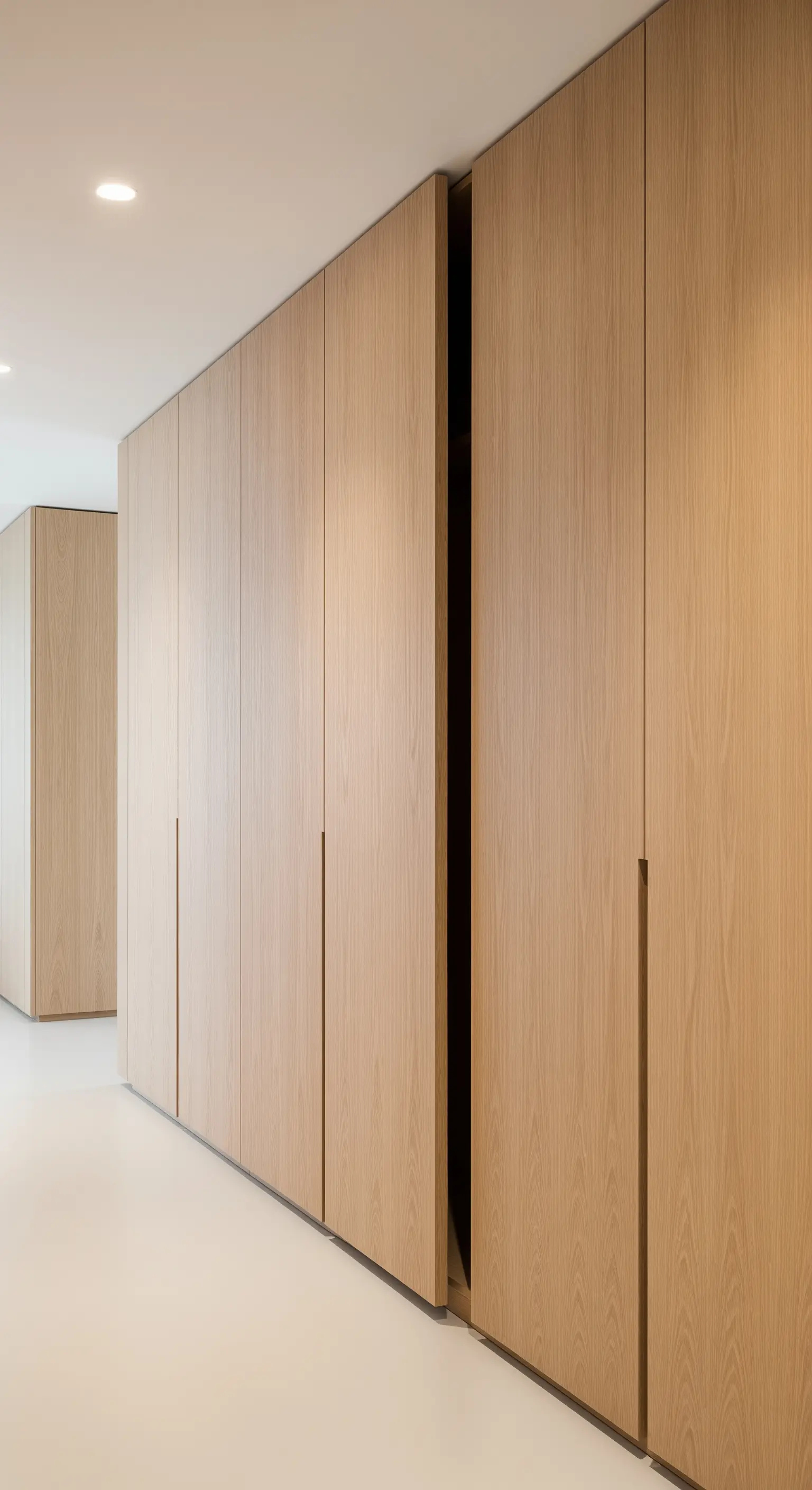 Deckenhohe Holzschränke mit integrierten, unauffälligen Griffleisten