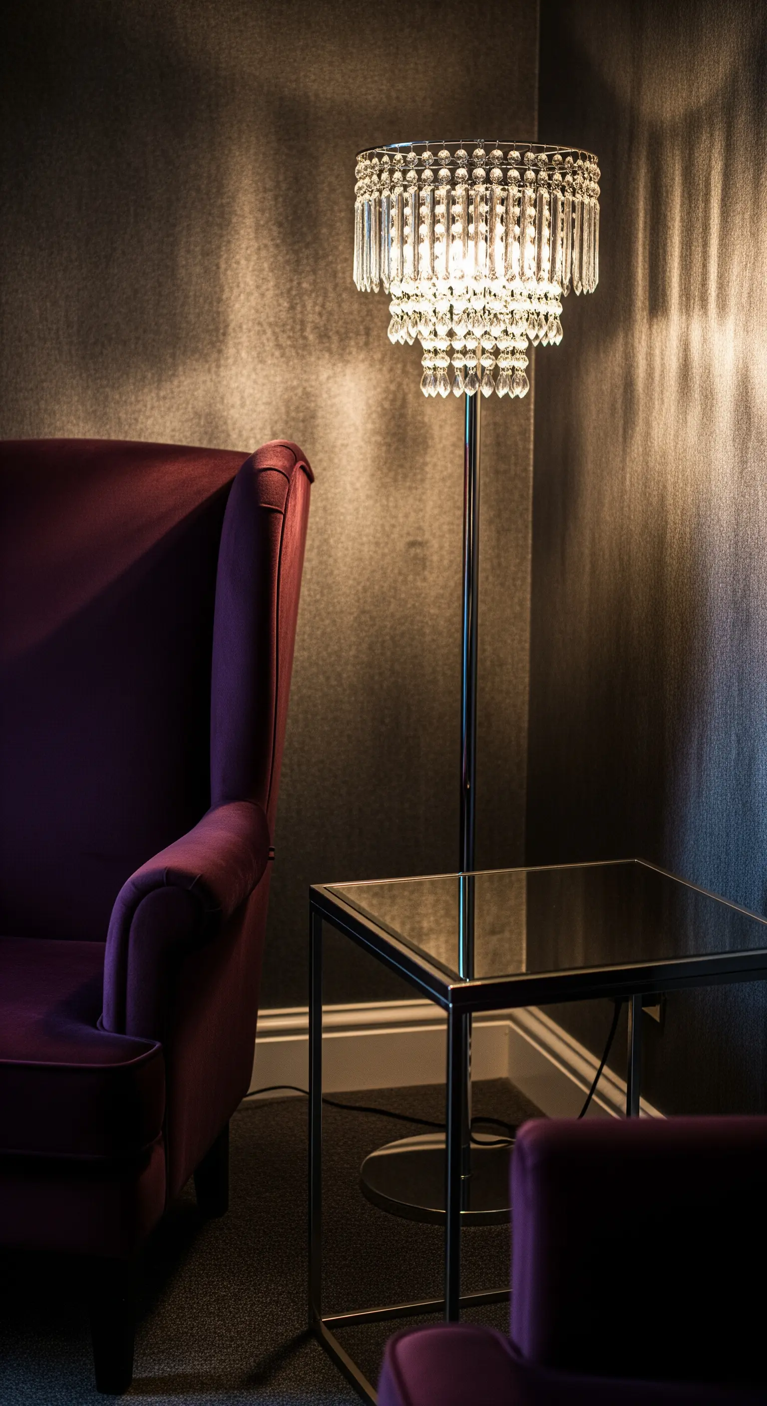 Kristall-Stehleuchte in einer dunklen Leseecke neben einem Samtsessel.