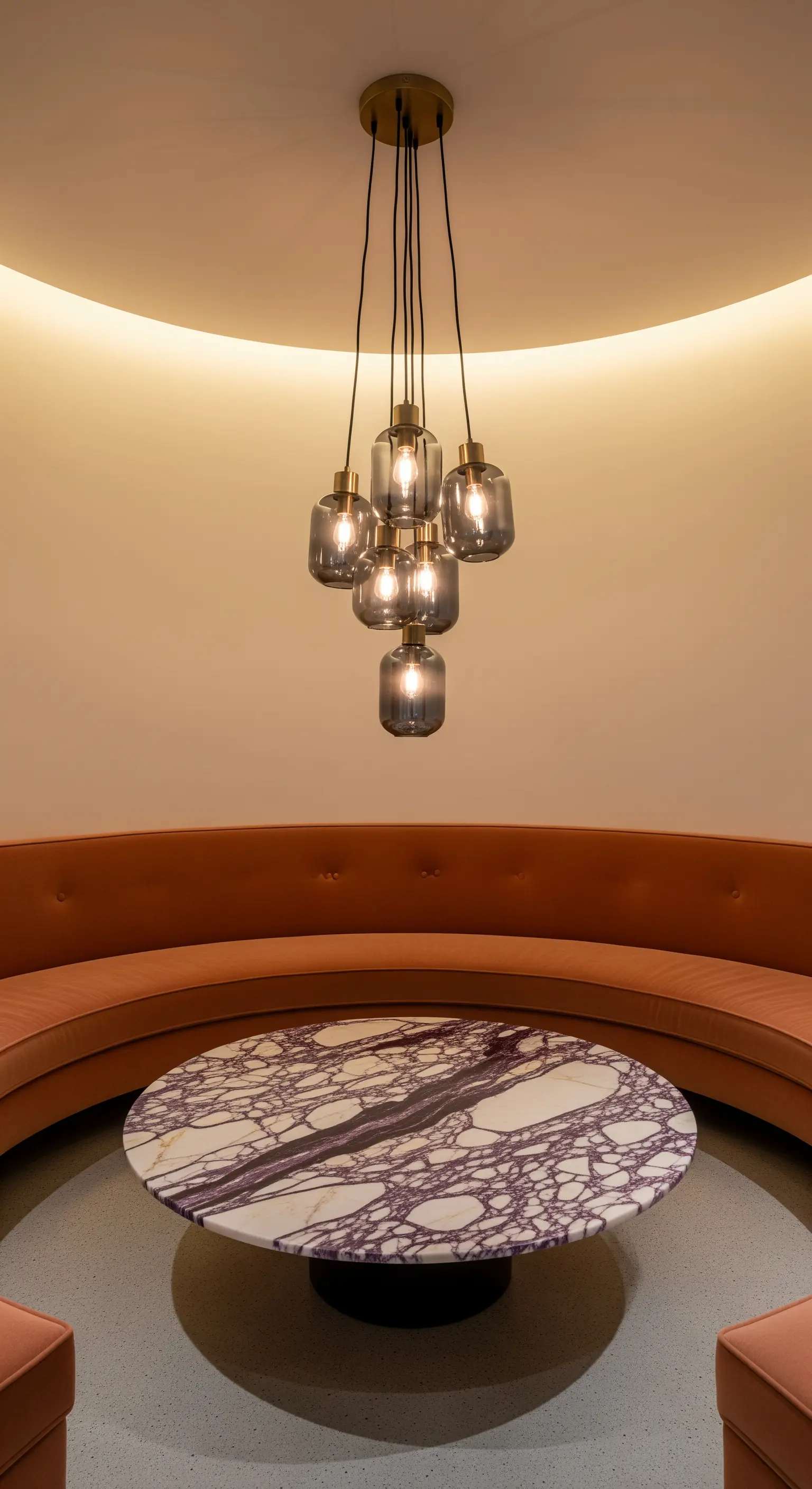 Runde Sitzecke mit Samtbank und einem Tisch aus violett gemasertem Marmor.