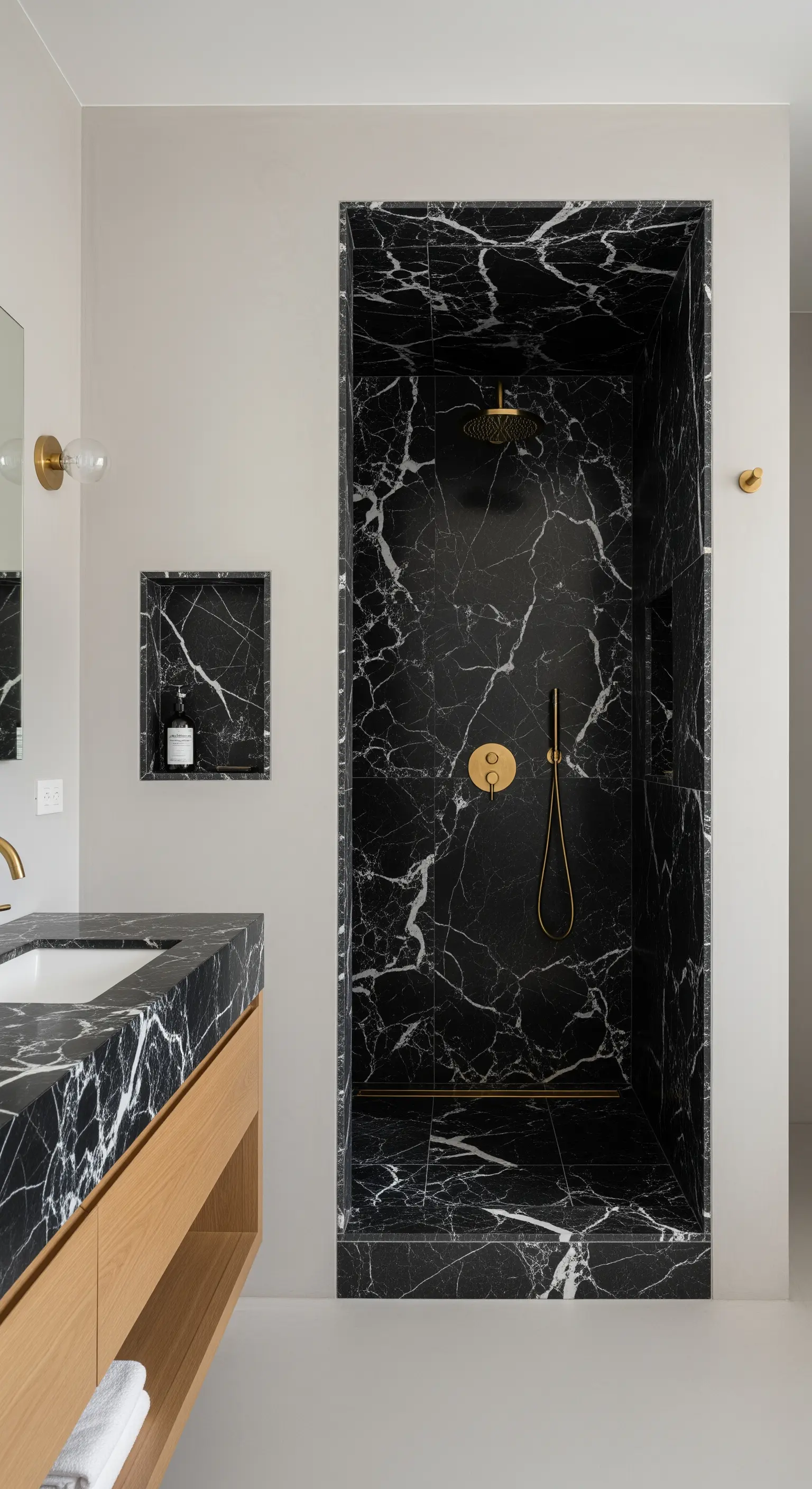 Duschkabine als schwarzer Marmor-Kubus in einem ansonsten hellen Badezimmer.