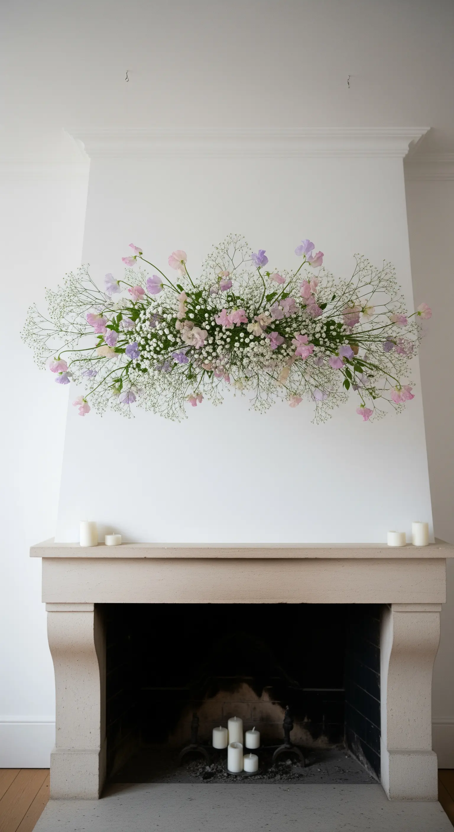 Eine schwebende Wolke aus Schleierkraut und Wicken über einem beigen Kaminsims.