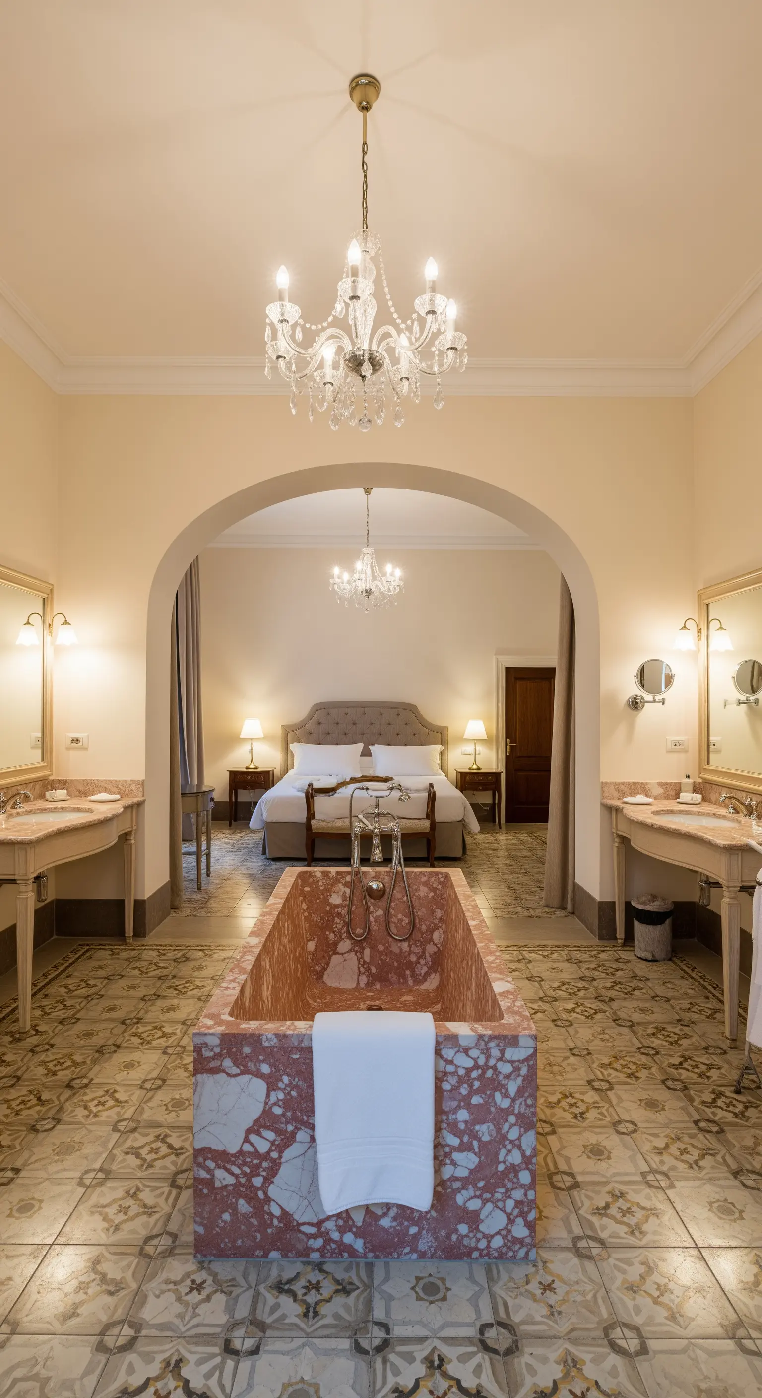 Offenes Badezimmer, das durch einen Bogen mit dem Schlafzimmer verbunden ist, mit zentraler Marmorwanne.