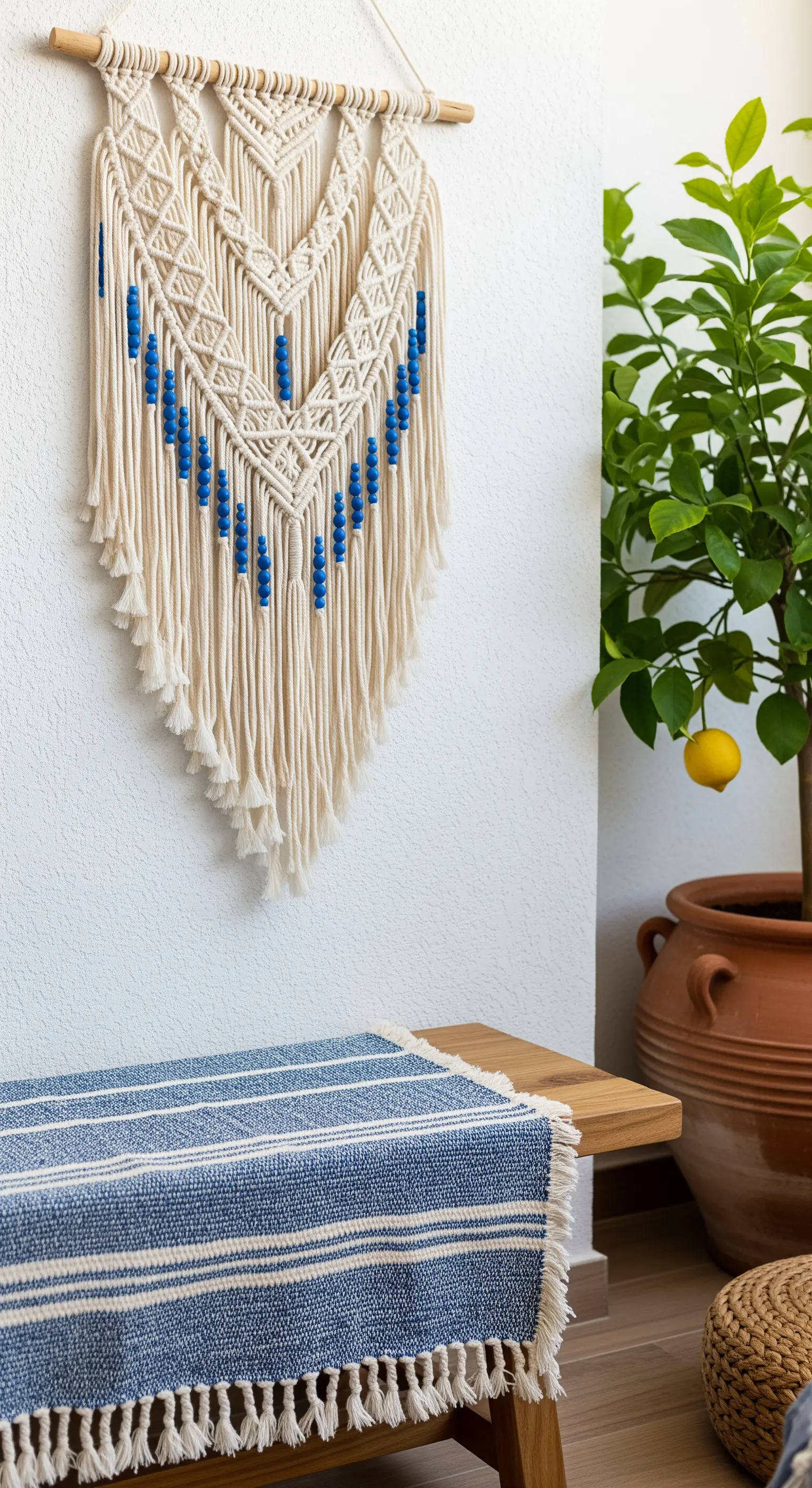 Makramee-Wandbehang mit blauen Perlen über einer Holzbank neben einem Zitronenbaum.