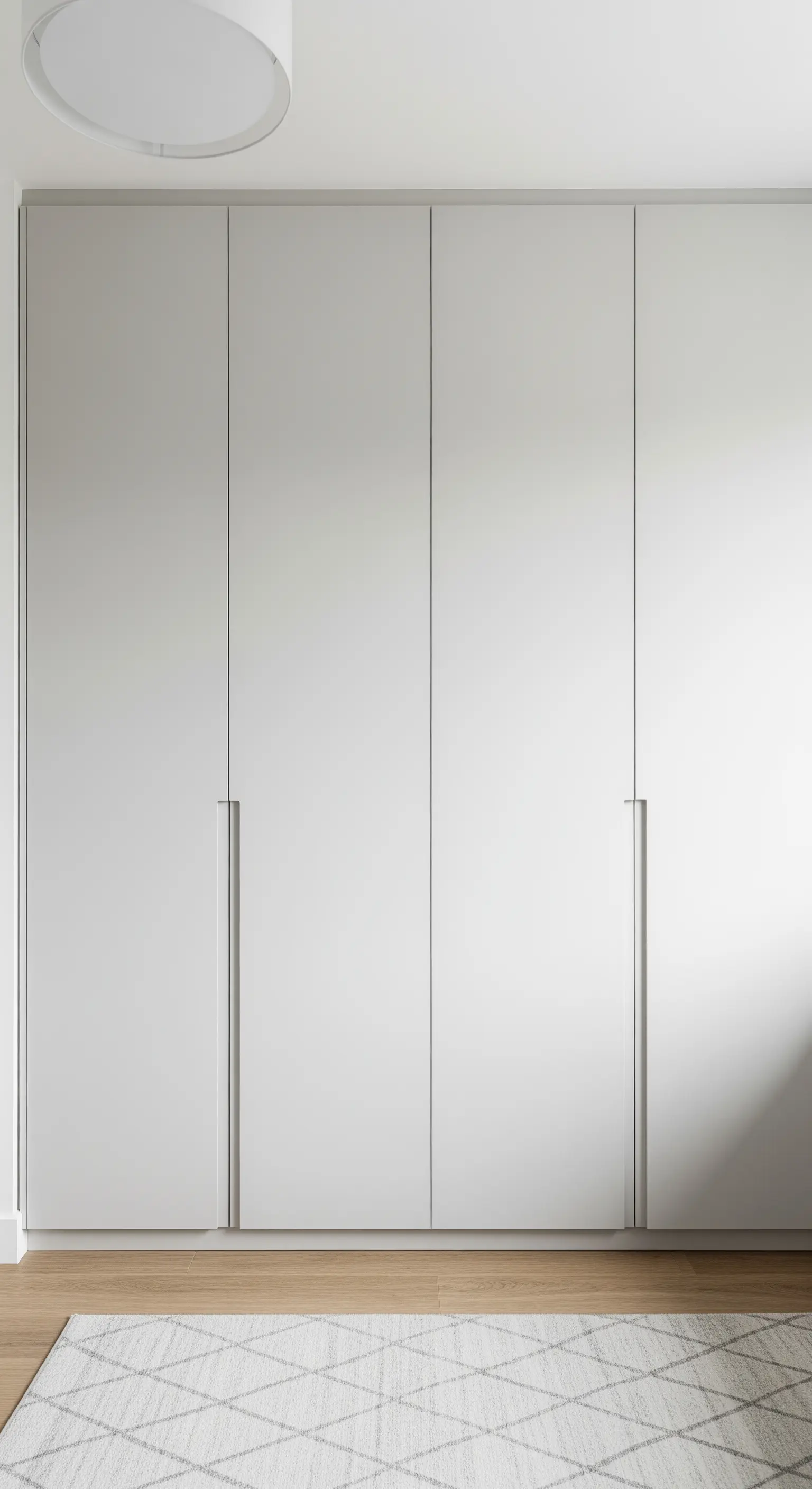 Hoher, griffloser Einbauschrank in hellem Grau, der sich nahtlos in die Wand einfügt.