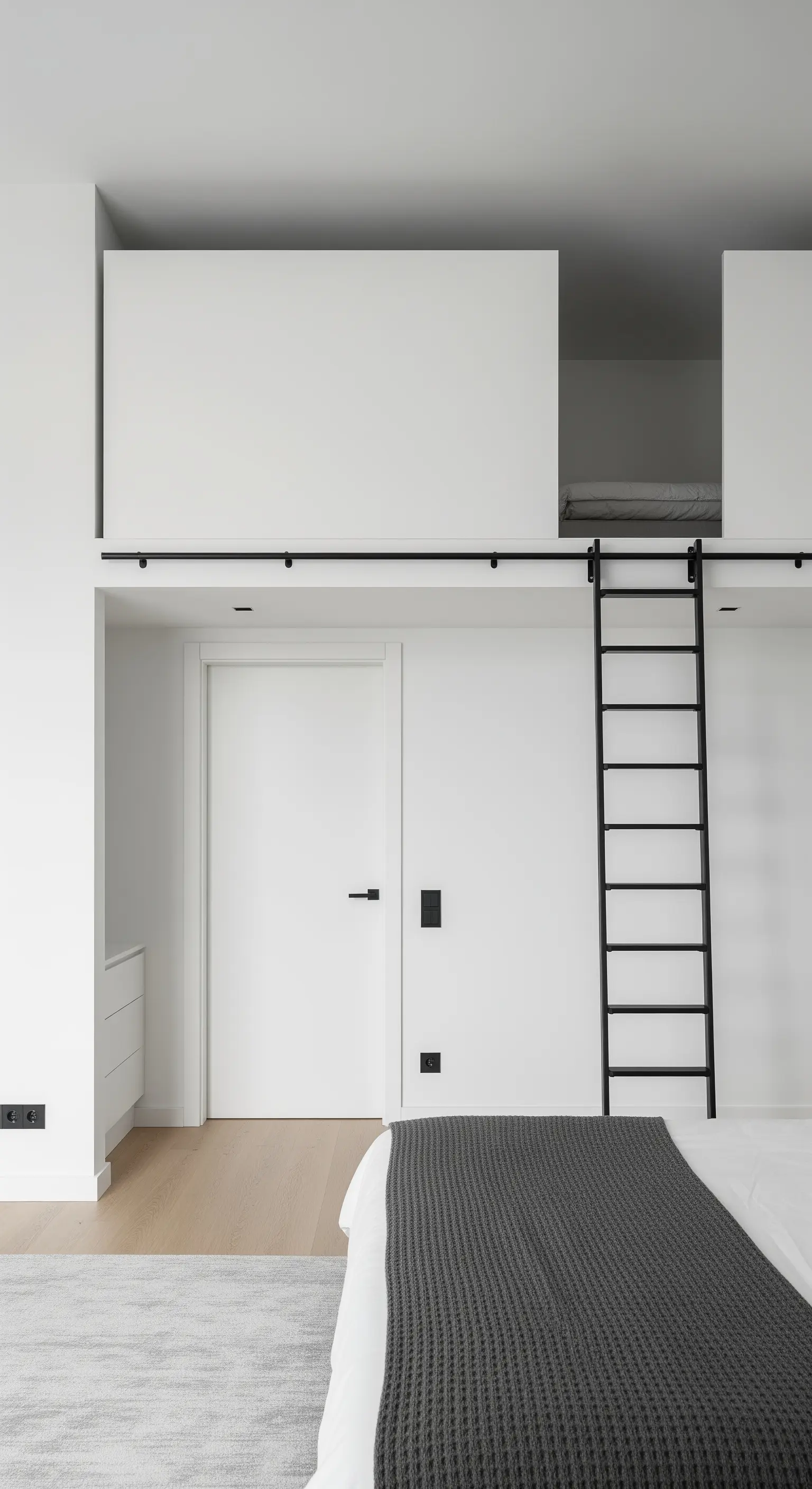 Minimalistisches weißes Zimmer mit Hochbett und schwarzer Leiter für maximale Raumnutzung.