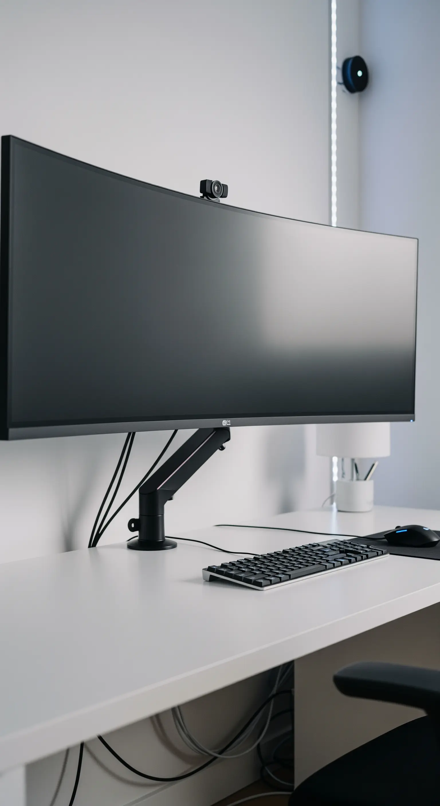 Aufgeräumter Schreibtisch mit Monitorarm und sauberem Kabelmanagement.