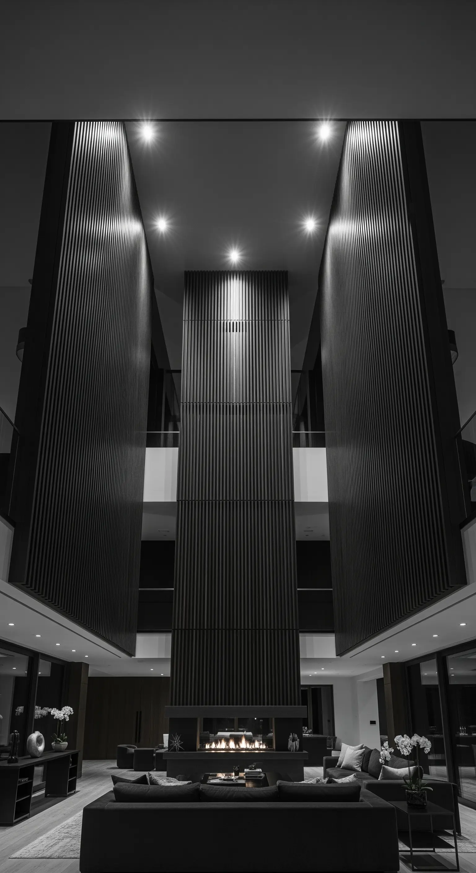 Hoher Raum mit raumhohen Lamellenwänden und gezielter Deckenbeleuchtung.