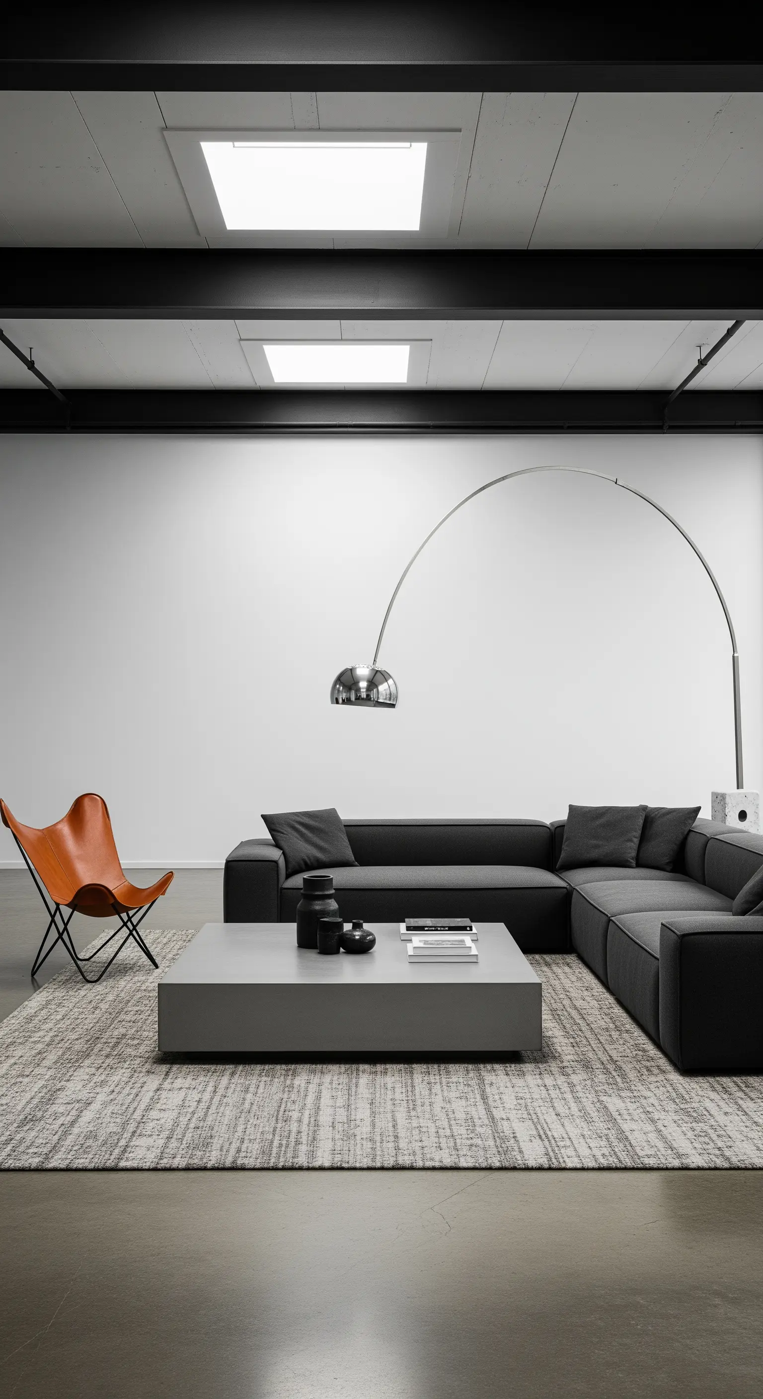 Modernes Loft-Wohnzimmer mit dunklem Sofa, Beton-Couchtisch und einer großen Bogenlampe.