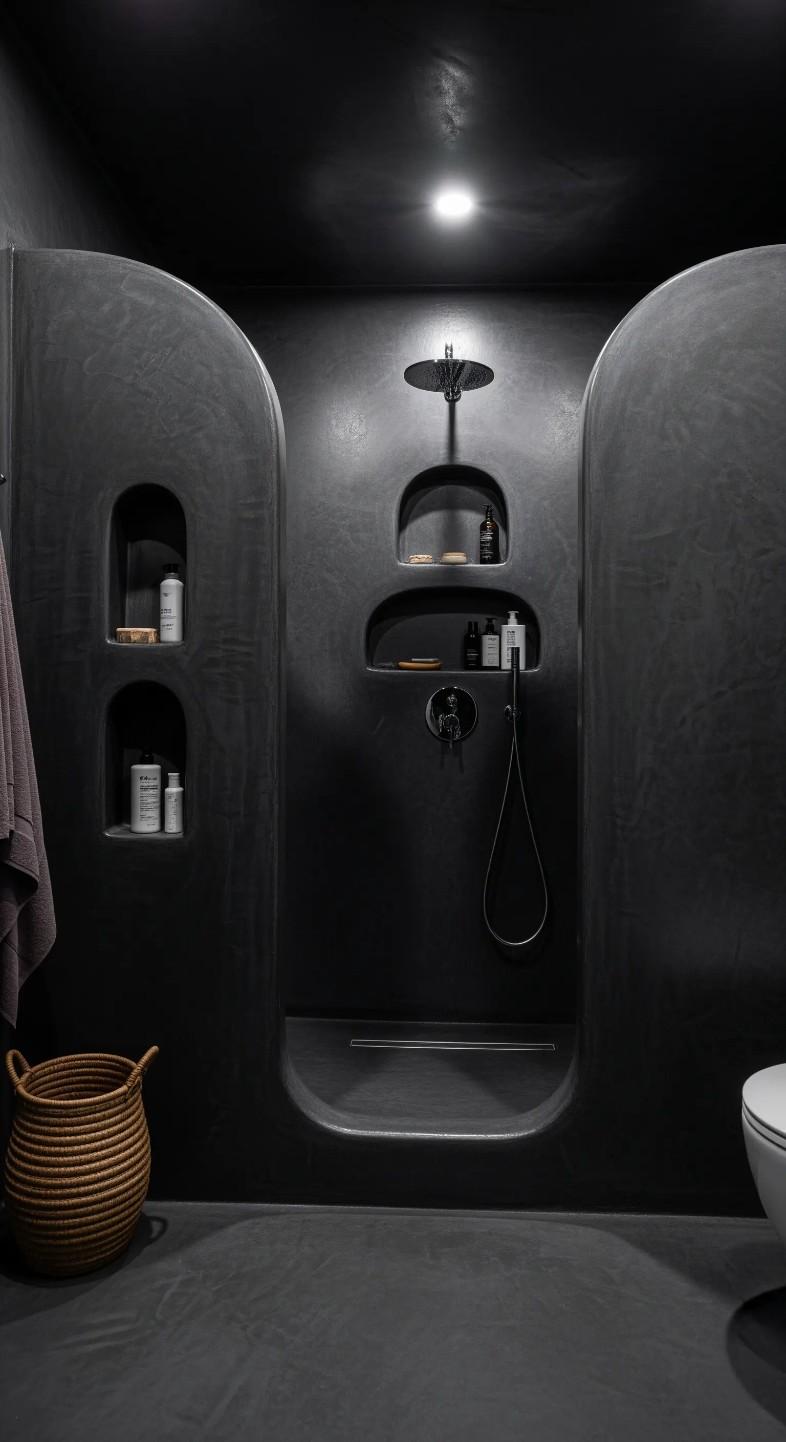 Dunkle, fugenlose Dusche aus Mikrozement mit organisch geformten Nischen