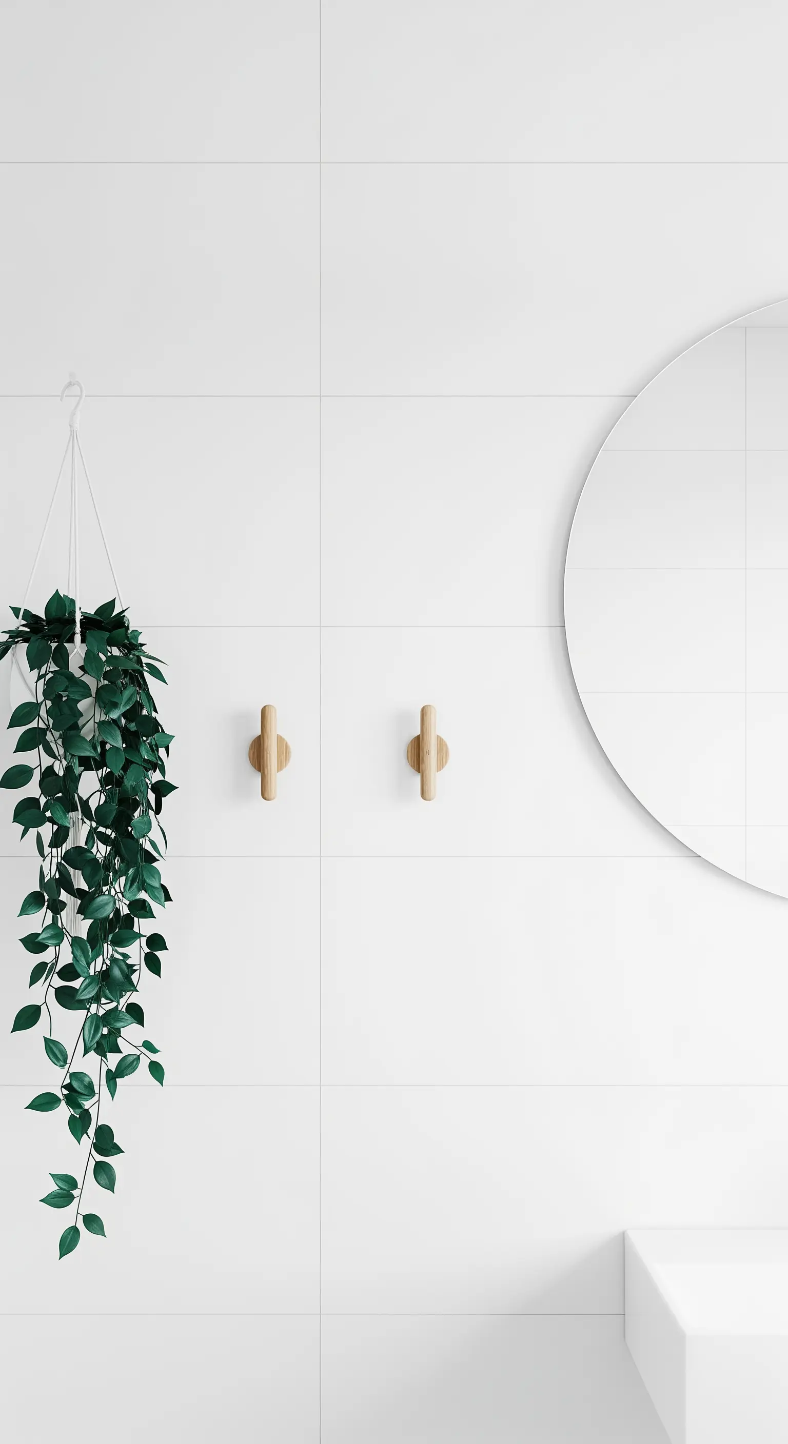Hängepflanze in einem weißen Topf an einer weißen Fliesenwand im Badezimmer.